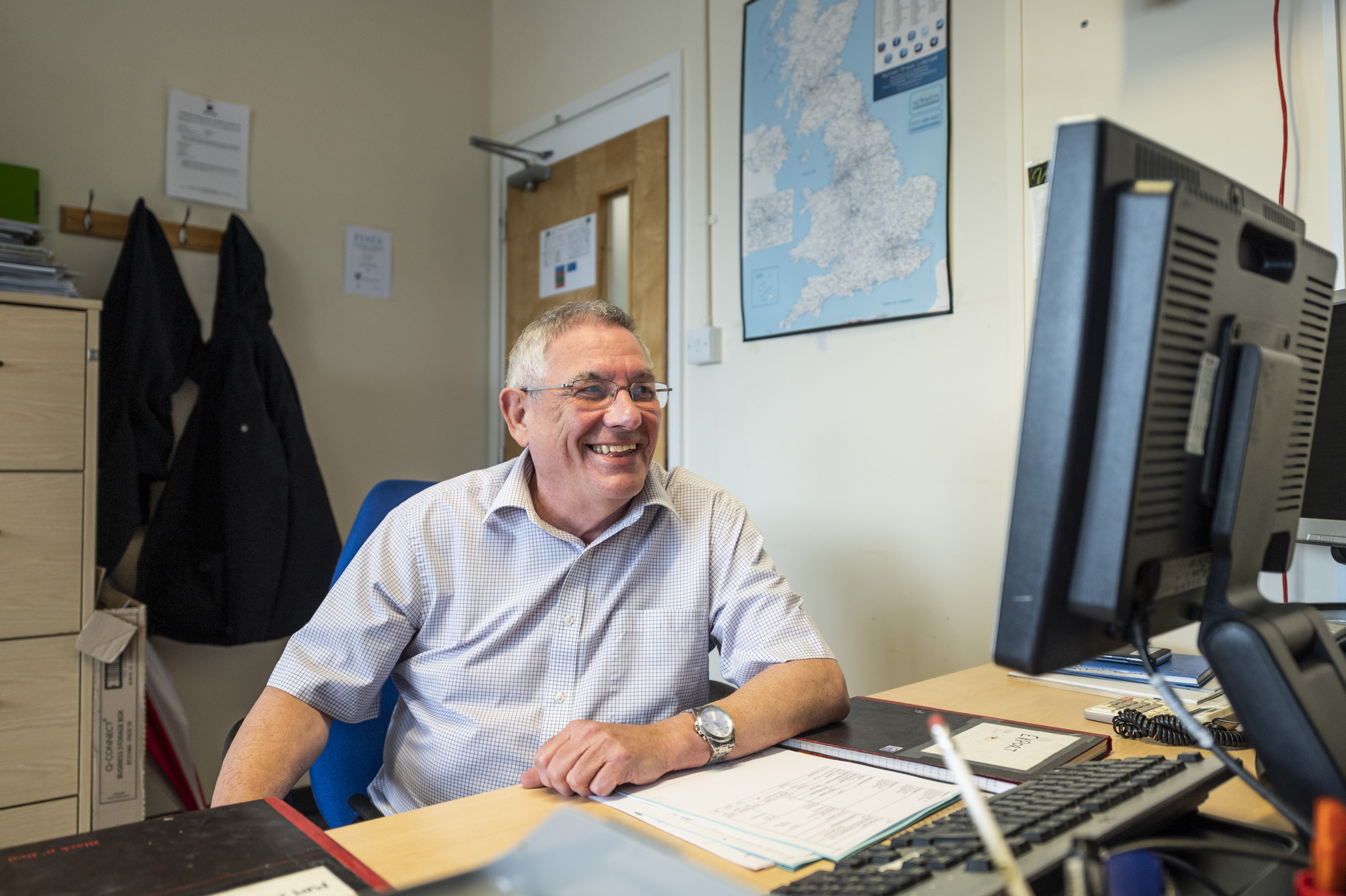 Meeting room at Liverpool Film Studios with a smiling event planner at his computer.