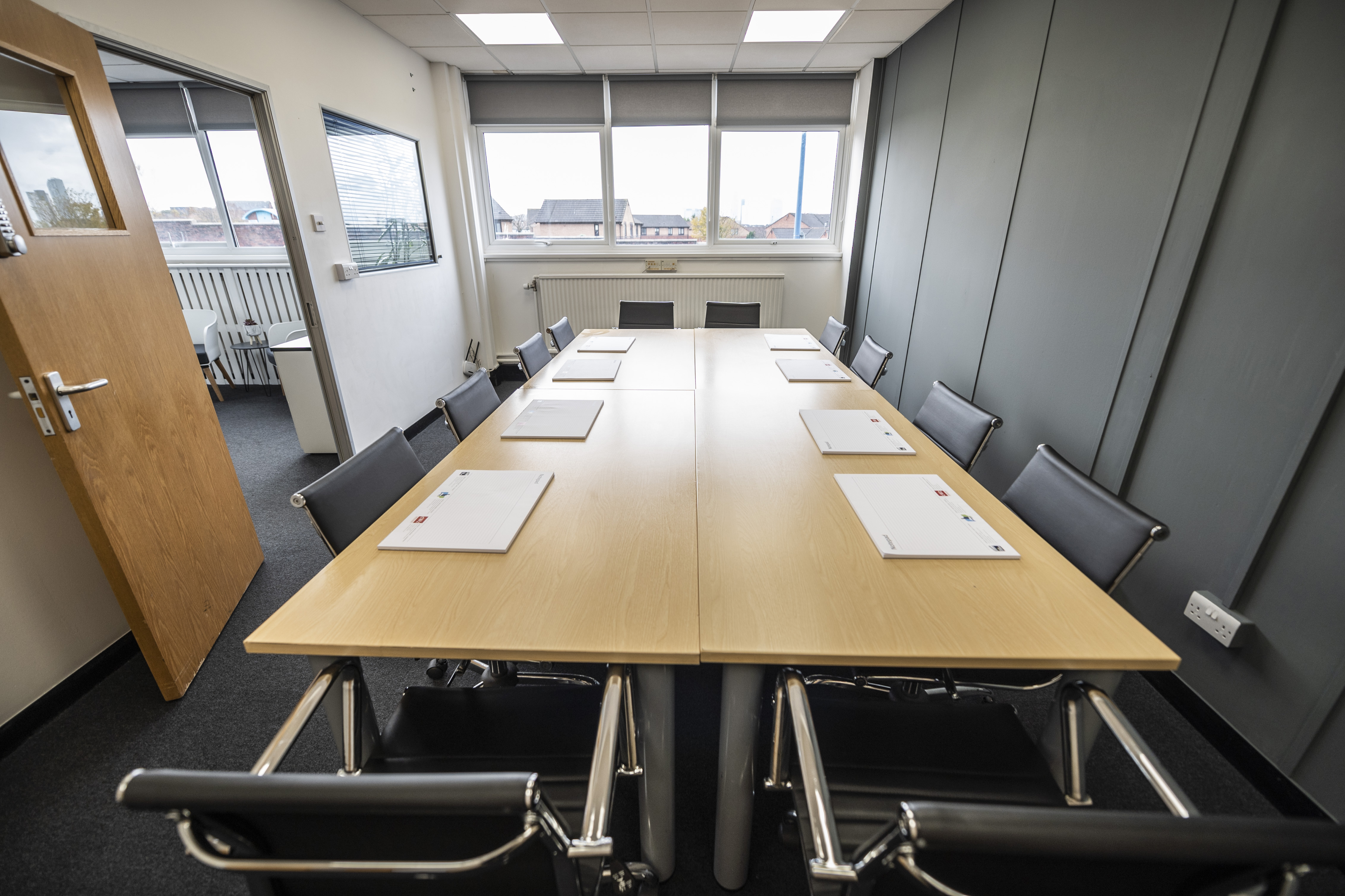 Meeting room with long wooden table, ideal for corporate meetings and workshops.