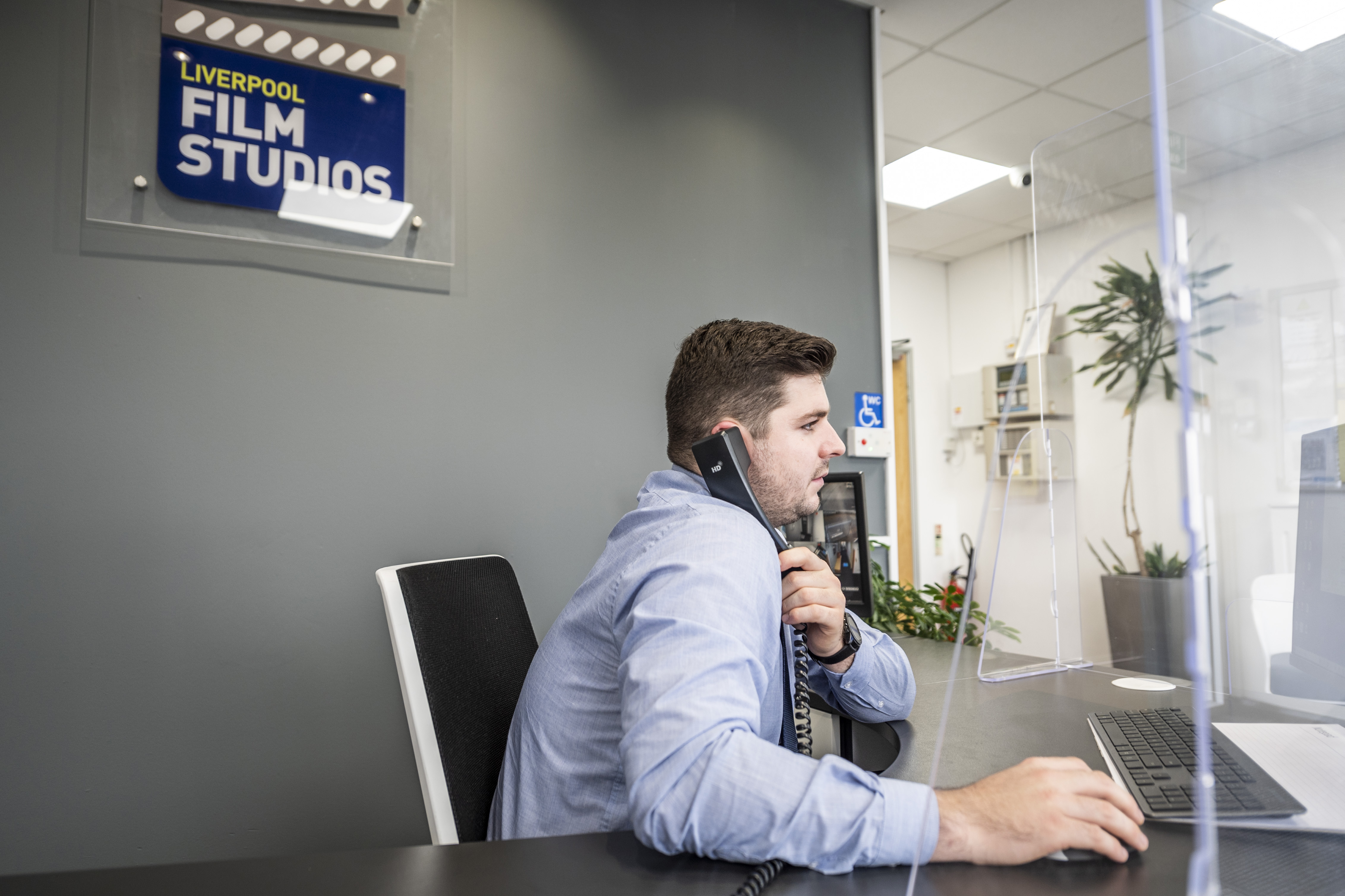 Professional at reception desk in Liverpool Film Studios, ideal for film events and meetings.