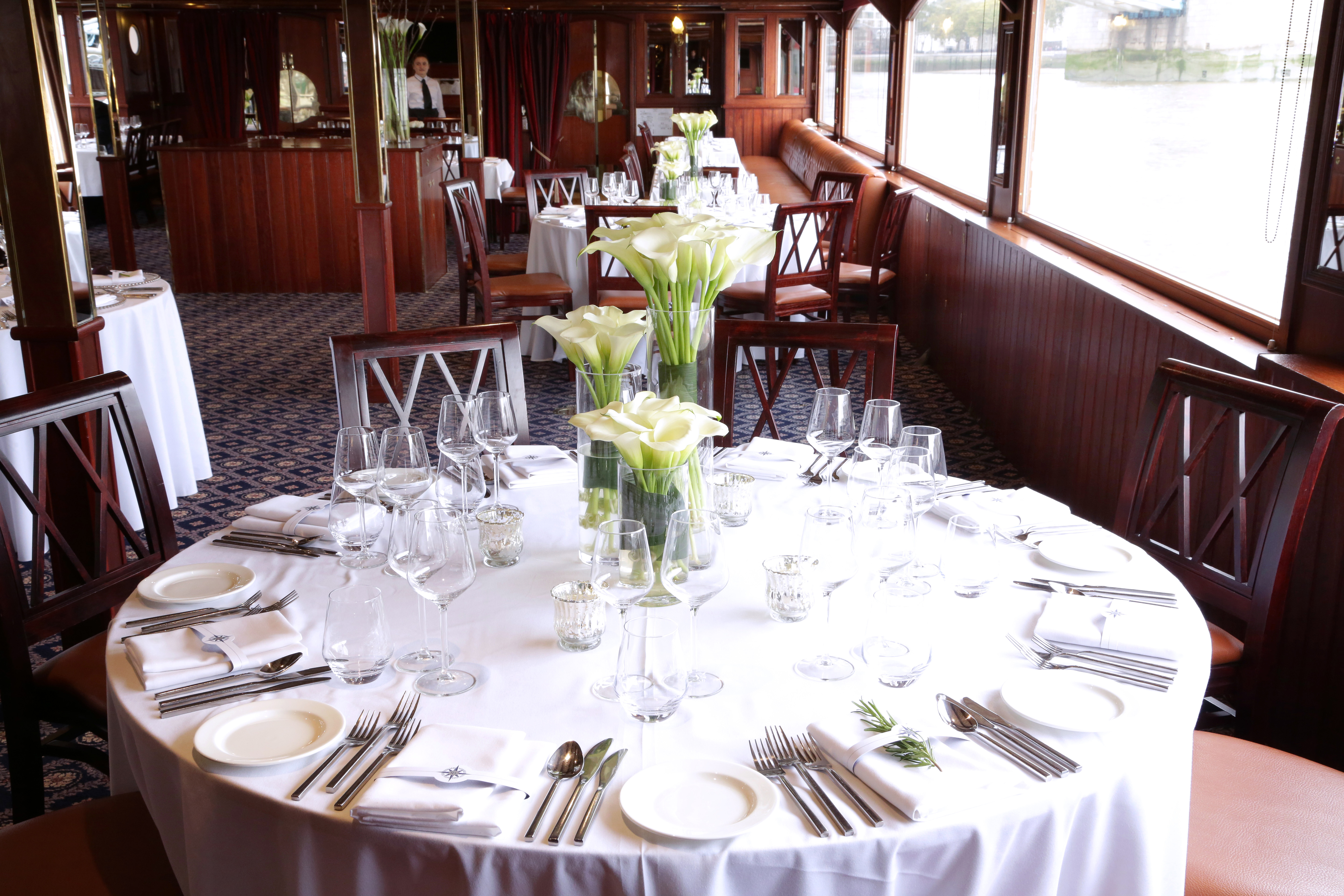 Elegant dining area on a boat, perfect for upscale corporate events and intimate gatherings.