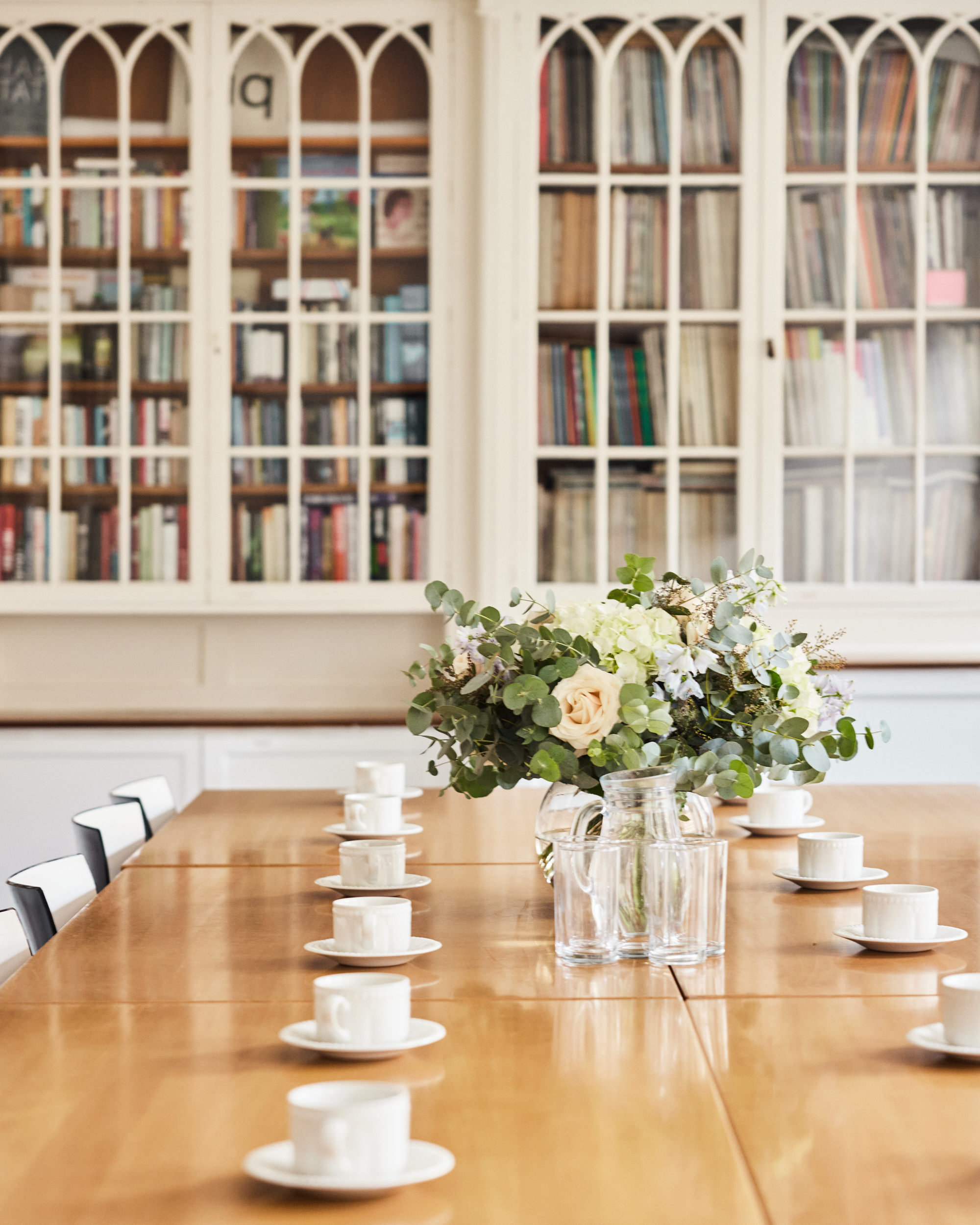 Elegant meeting space in The Bluecoat library with polished table and floral decor.