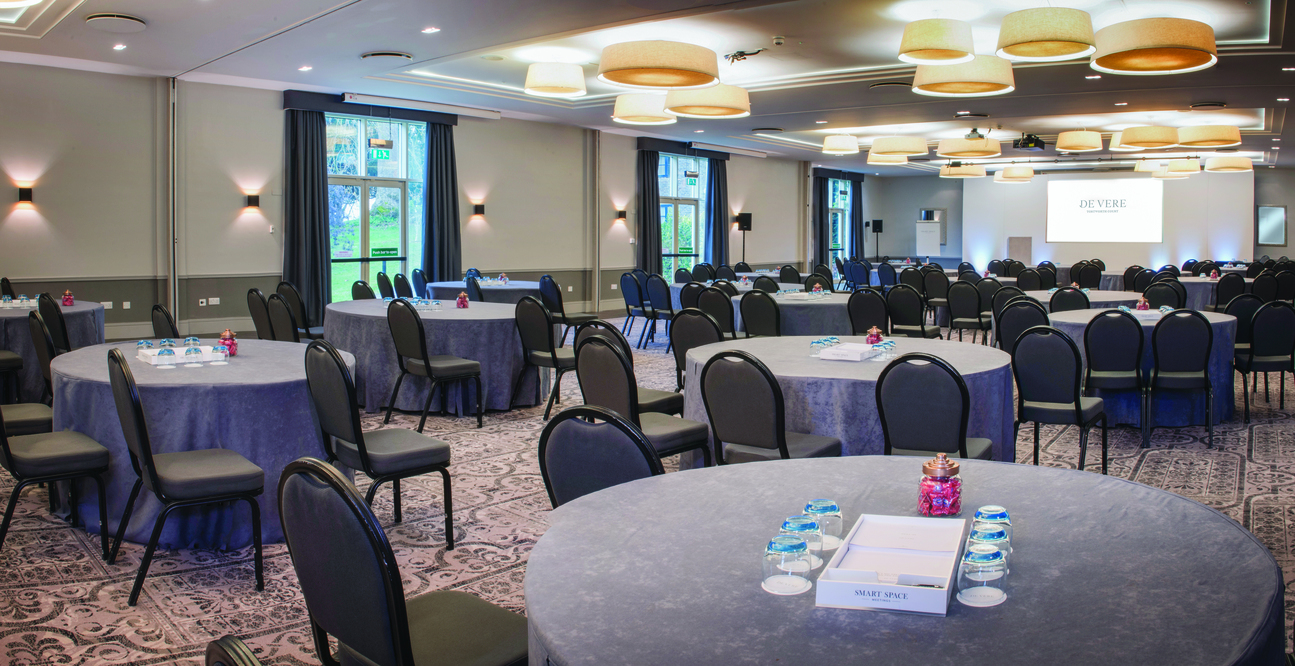 Event space at De Vere Tortworth Court with blue tablecloths for corporate meetings.