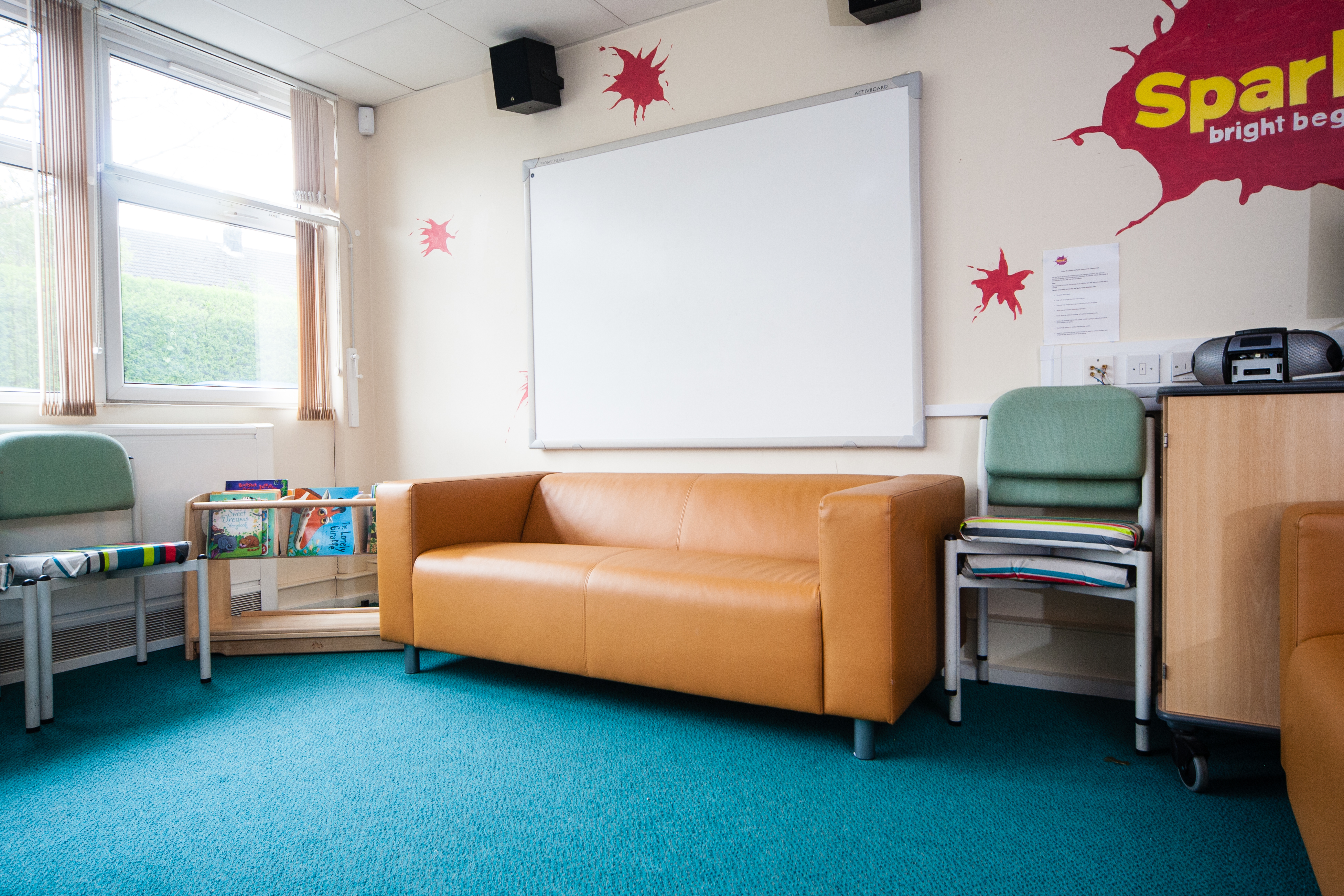 Cozy meeting space with orange sofa for brainstorming at Spark Burntwood CIC.
