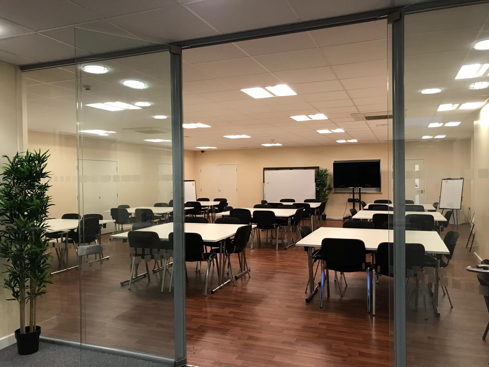 Modern conference hall with glass walls, ideal for workshops and team meetings.