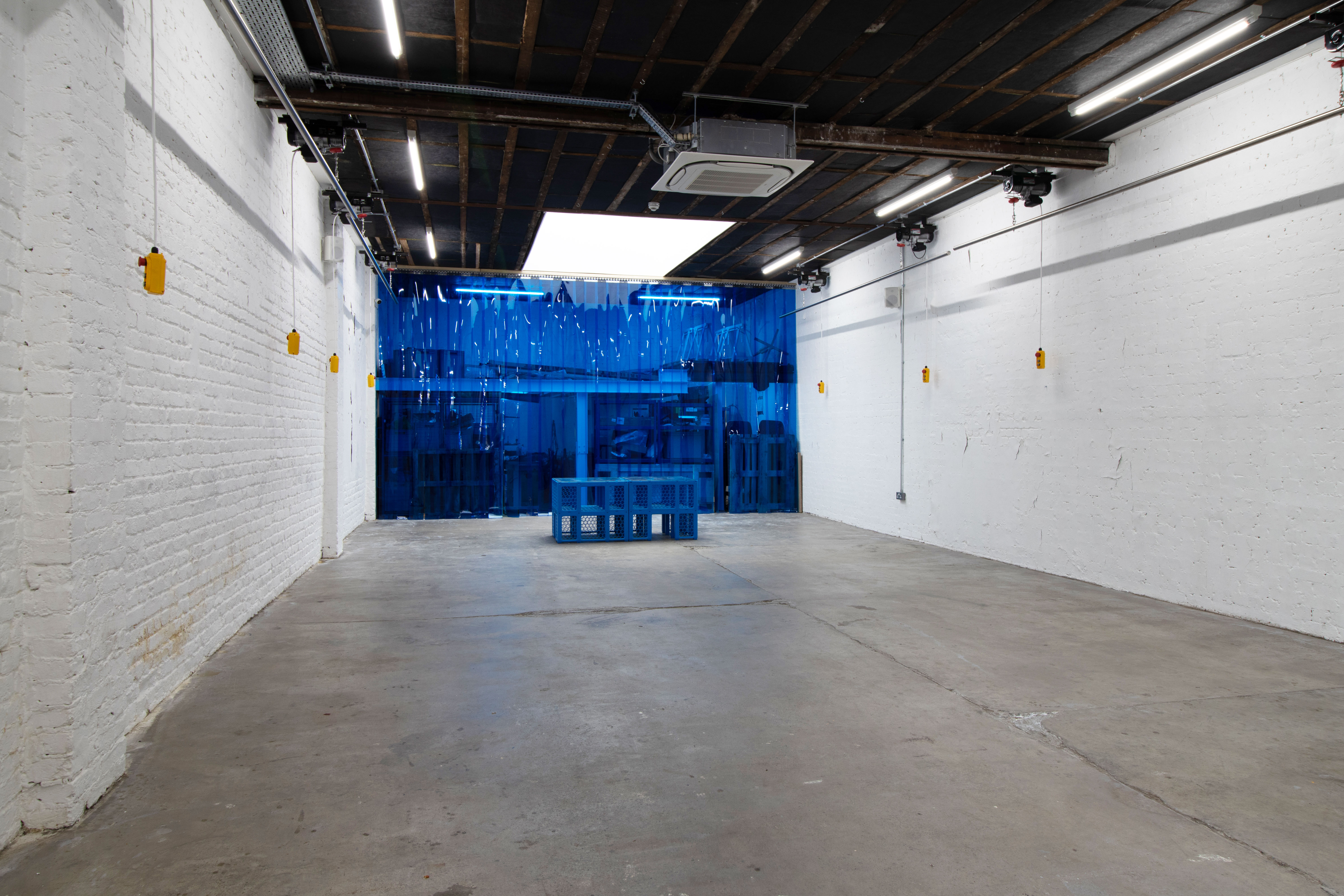 Versatile event space with exposed brick and blue backdrop for networking and presentations.