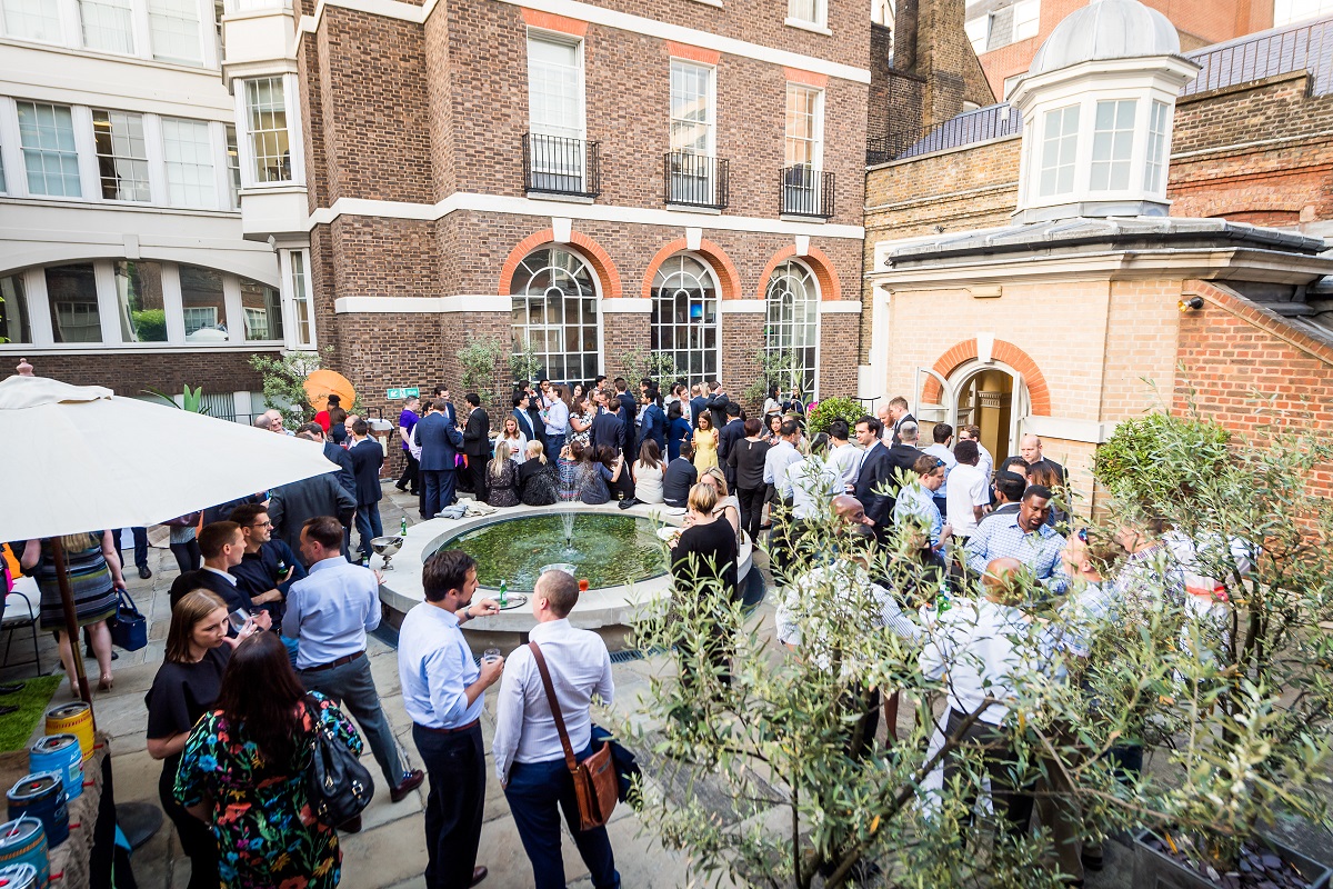 Vibrant outdoor networking event at Skinners' Hall with diverse attendees and fountain.