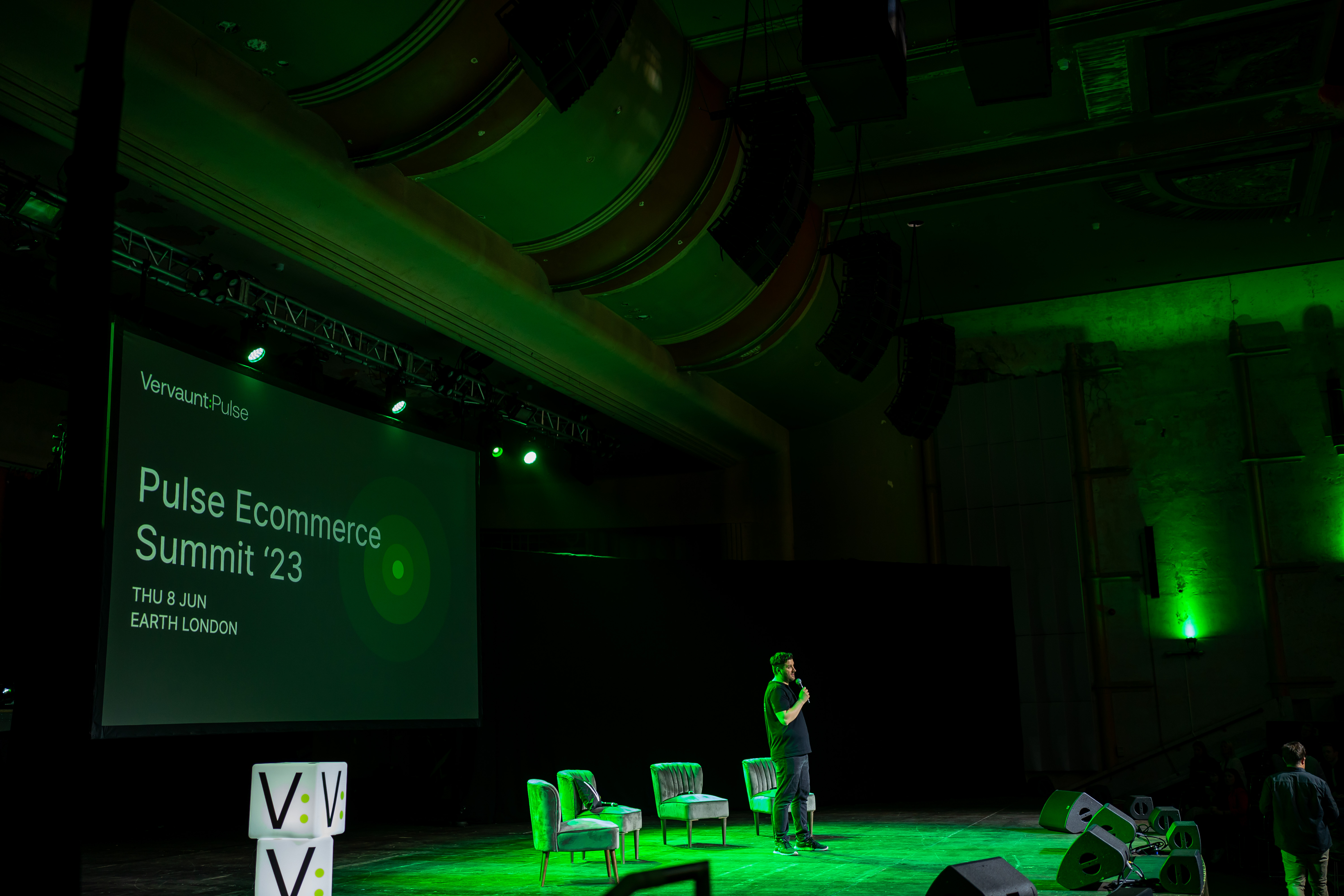 Theatre stage setup for Pulse Ecommerce Summit '23 with dynamic lighting and seating.