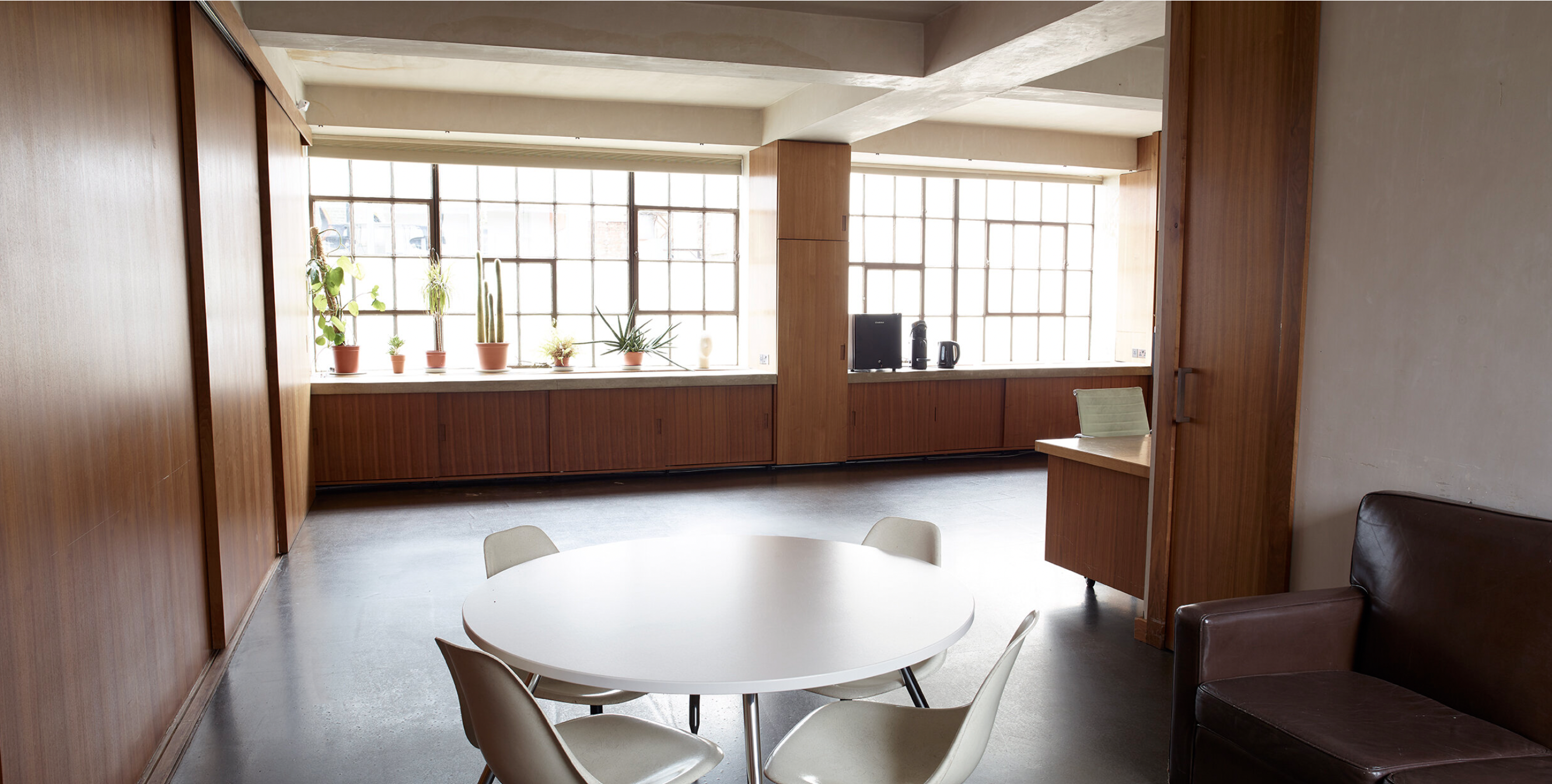 Bright meeting room with round table, ideal for seminars and events at Robert's Place Studios.