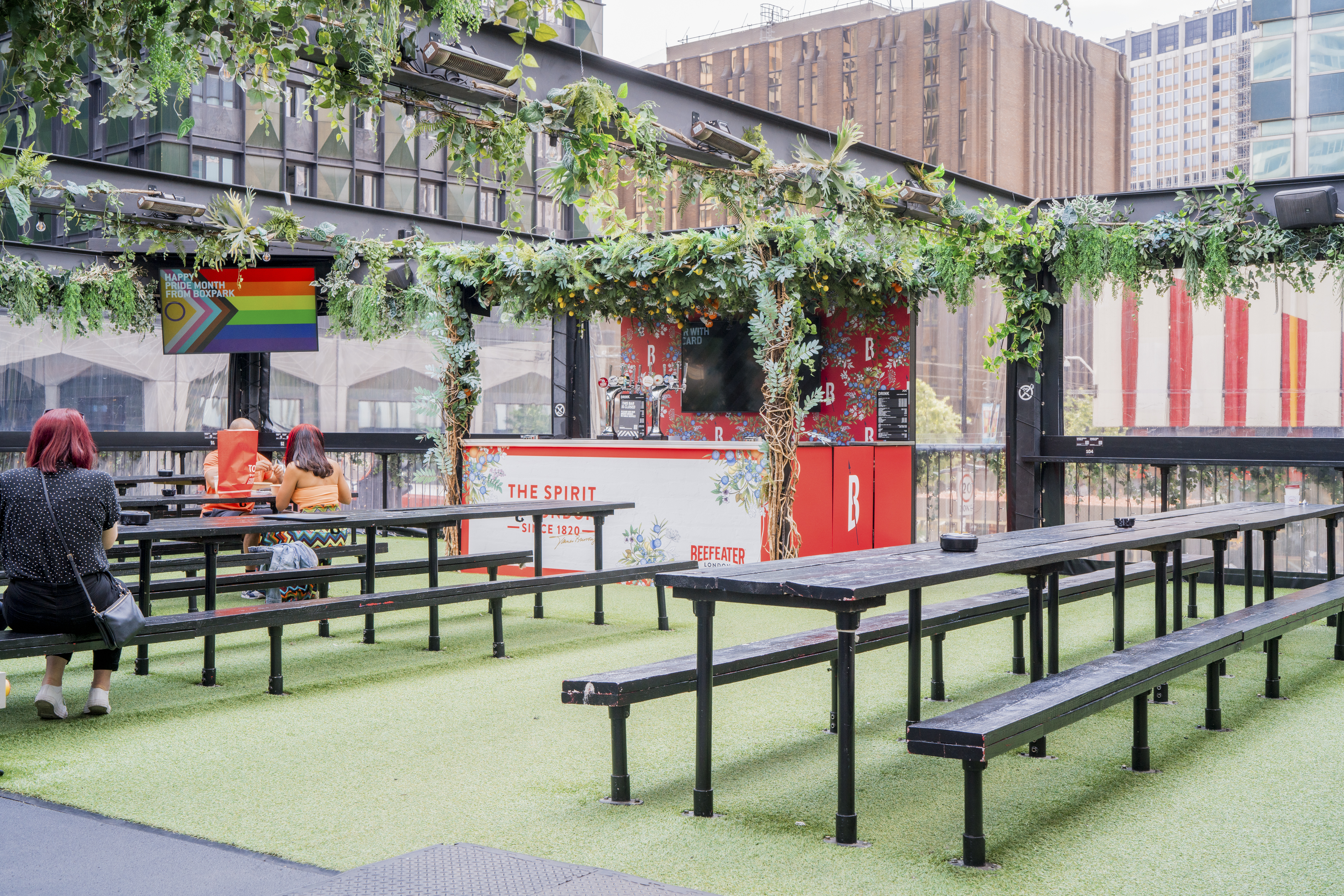 Vibrant outdoor event space with benches at Boxpark Croydon, ideal for social gatherings.