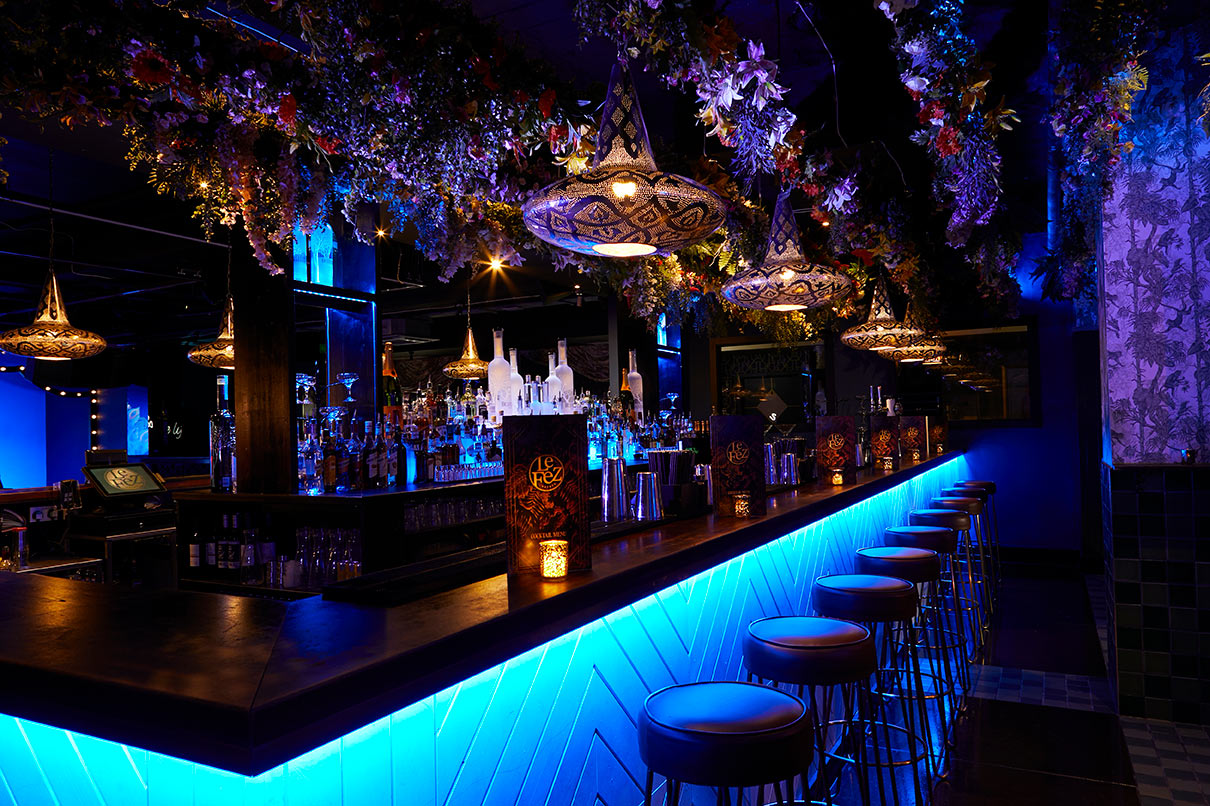 Stylish bar in Le Jardin, Le Fez with vibrant blue lighting for upscale events.