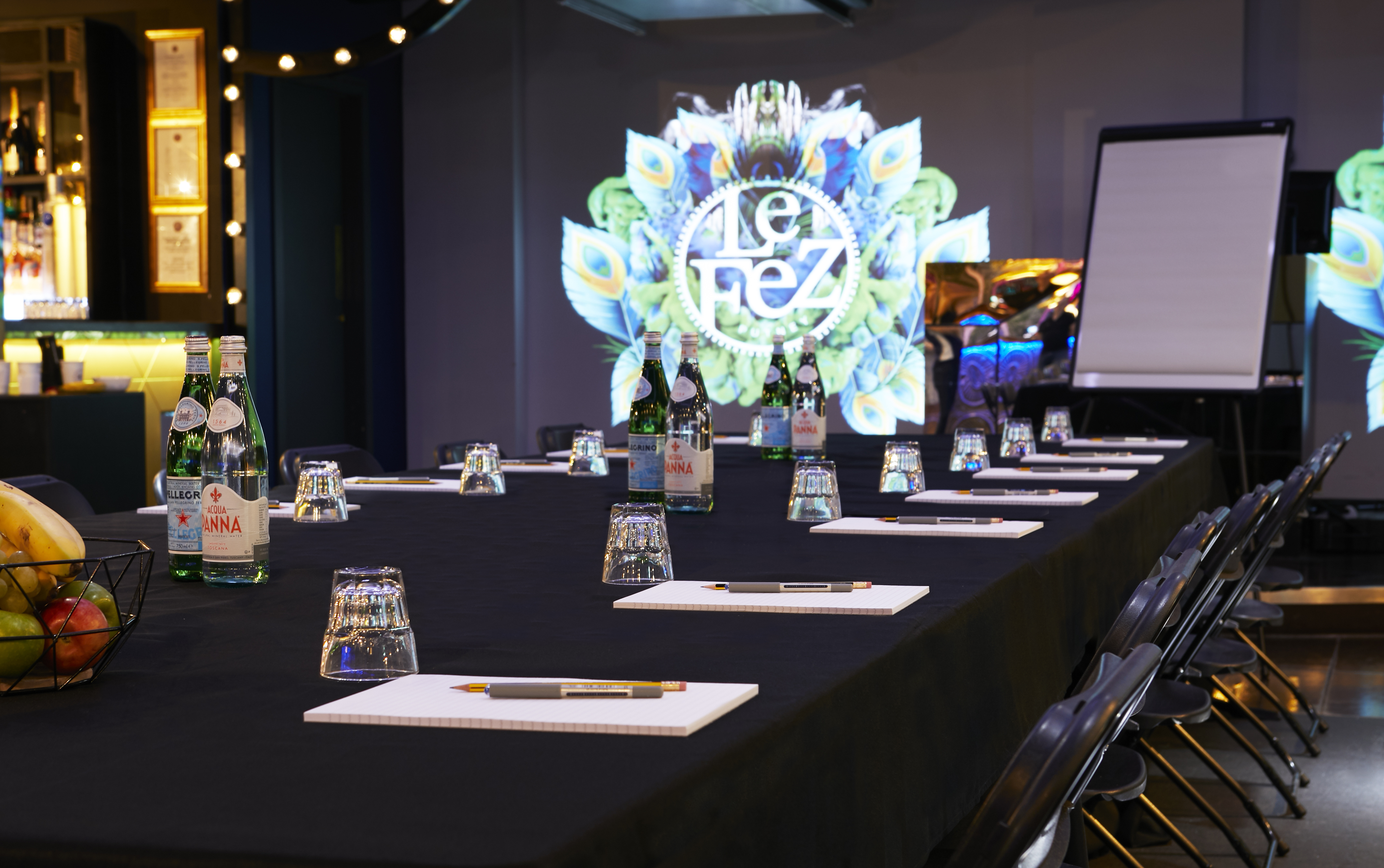 Meeting room at Le Club in Le Fez with black table, digital display, and wellness amenities.