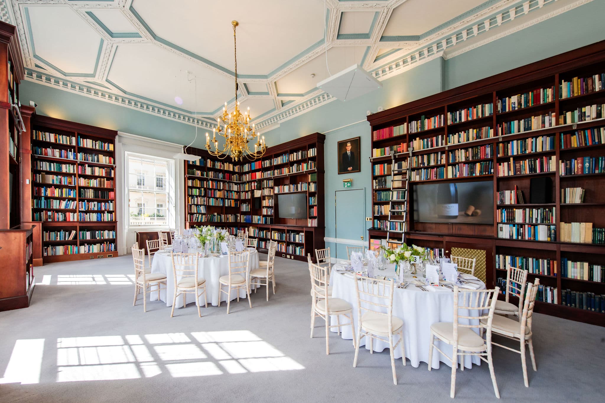 Historic library venue with floor-to-ceiling shelving for executive dinners and board meetings.