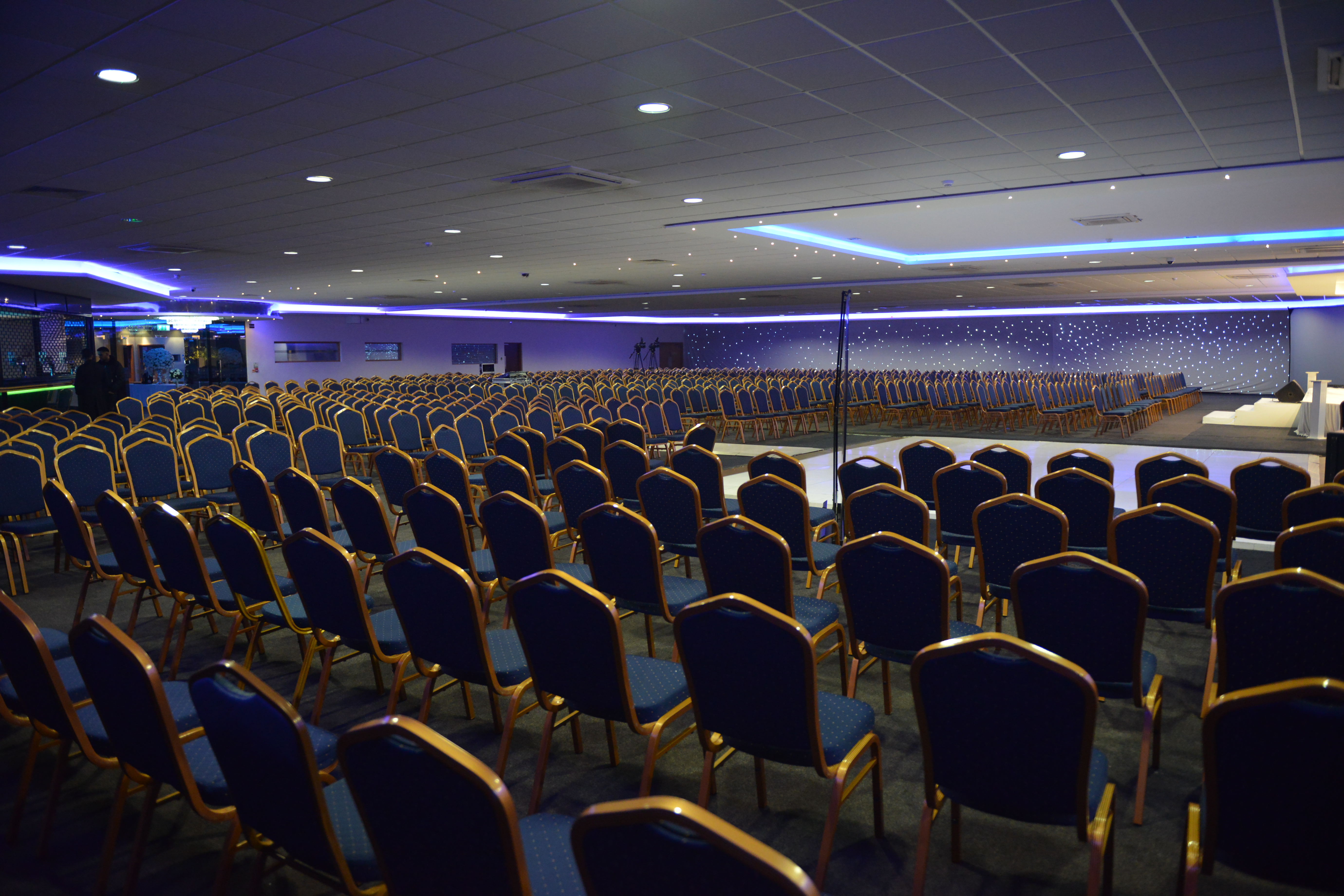 Spacious Royale Banqueting Suite with blue chairs, perfect for conferences and presentations.