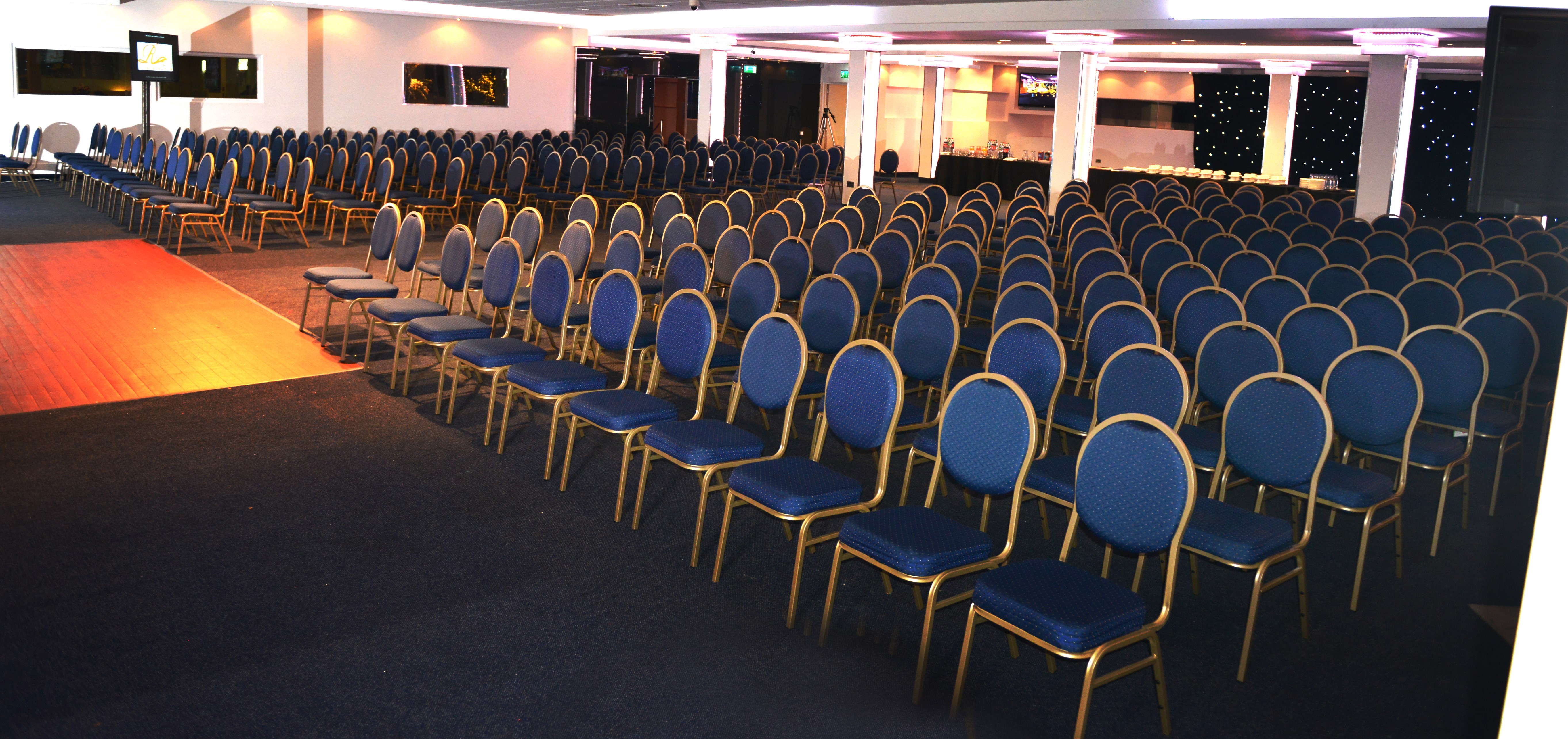 Executive lounge in Royale Banqueting Suite with blue chairs for conferences and presentations.
