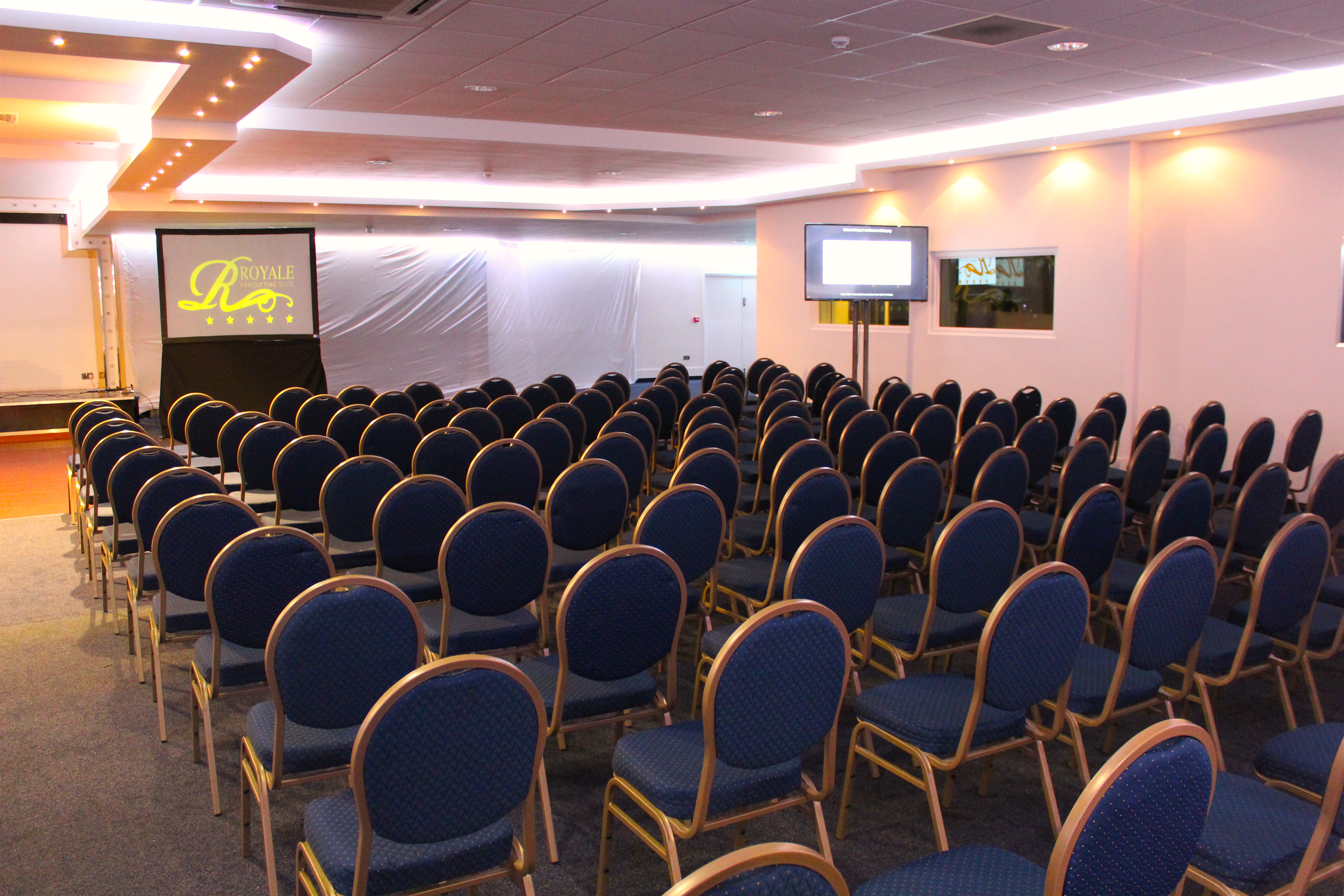 Executive lounge in Royale Banqueting Suite, blue chairs set for a conference event.