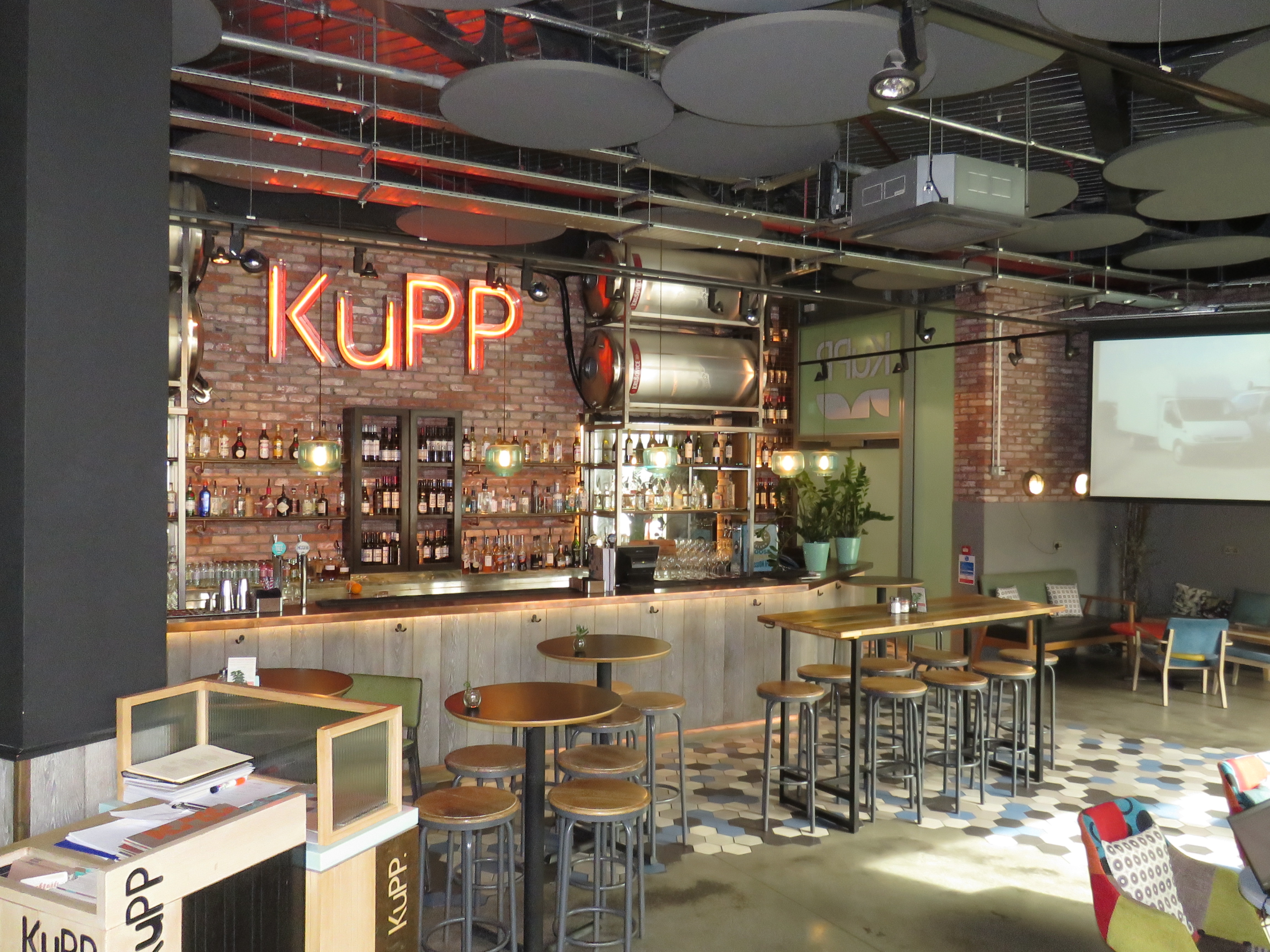 Modern bar at KuPP with exposed brick, ideal for networking and casual meetings.