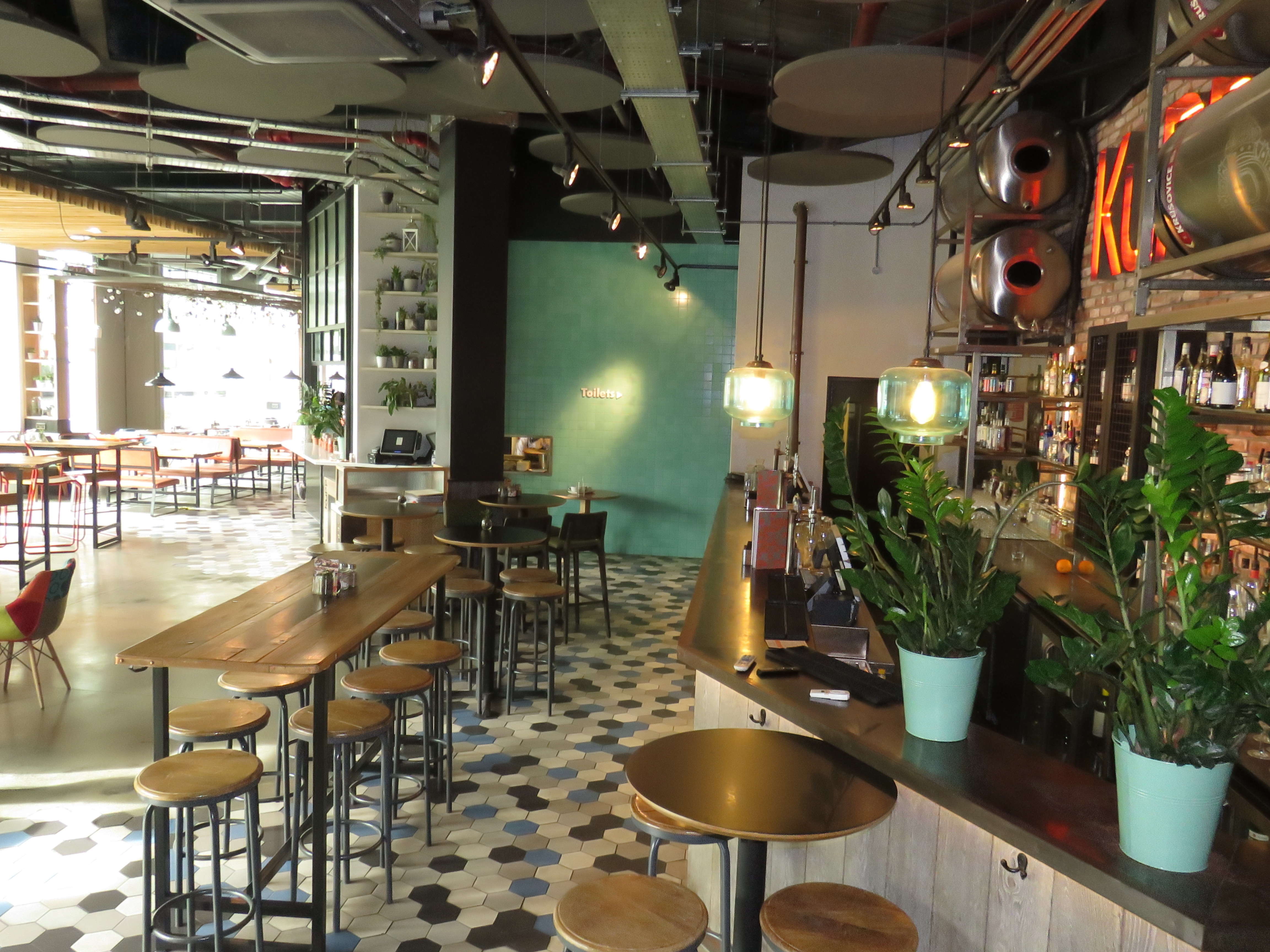 Modern bar at KuPP with vibrant decor, ideal for casual meetings and events.