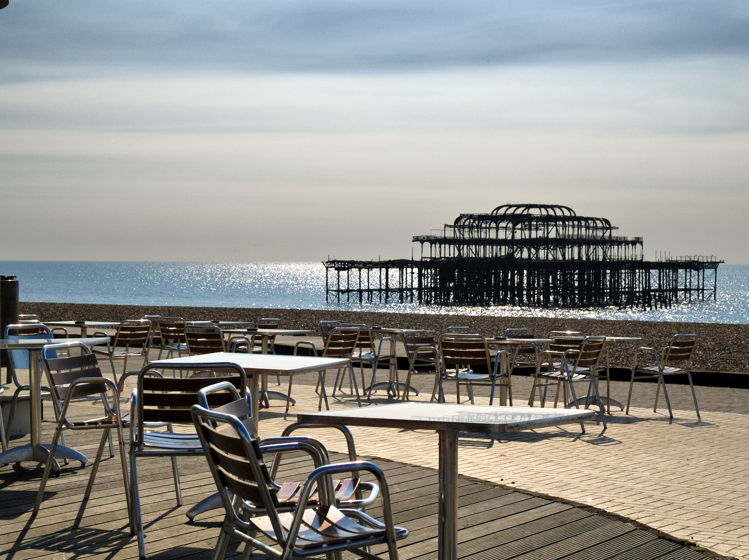 Brighton Beach Club outdoor meeting space with metal chairs and iconic pier backdrop.