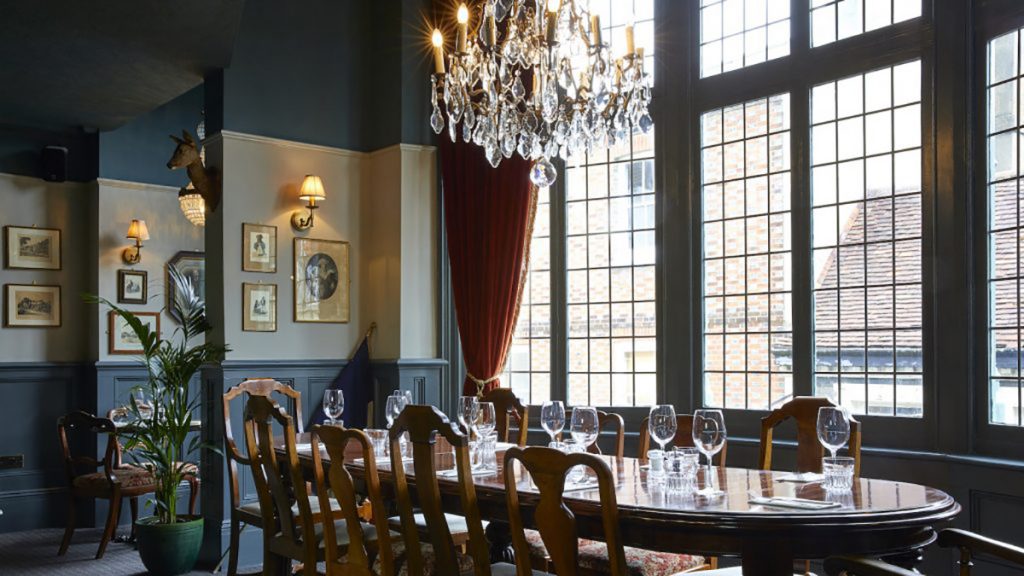 Elegant meeting space with wooden table, chandelier for corporate events.