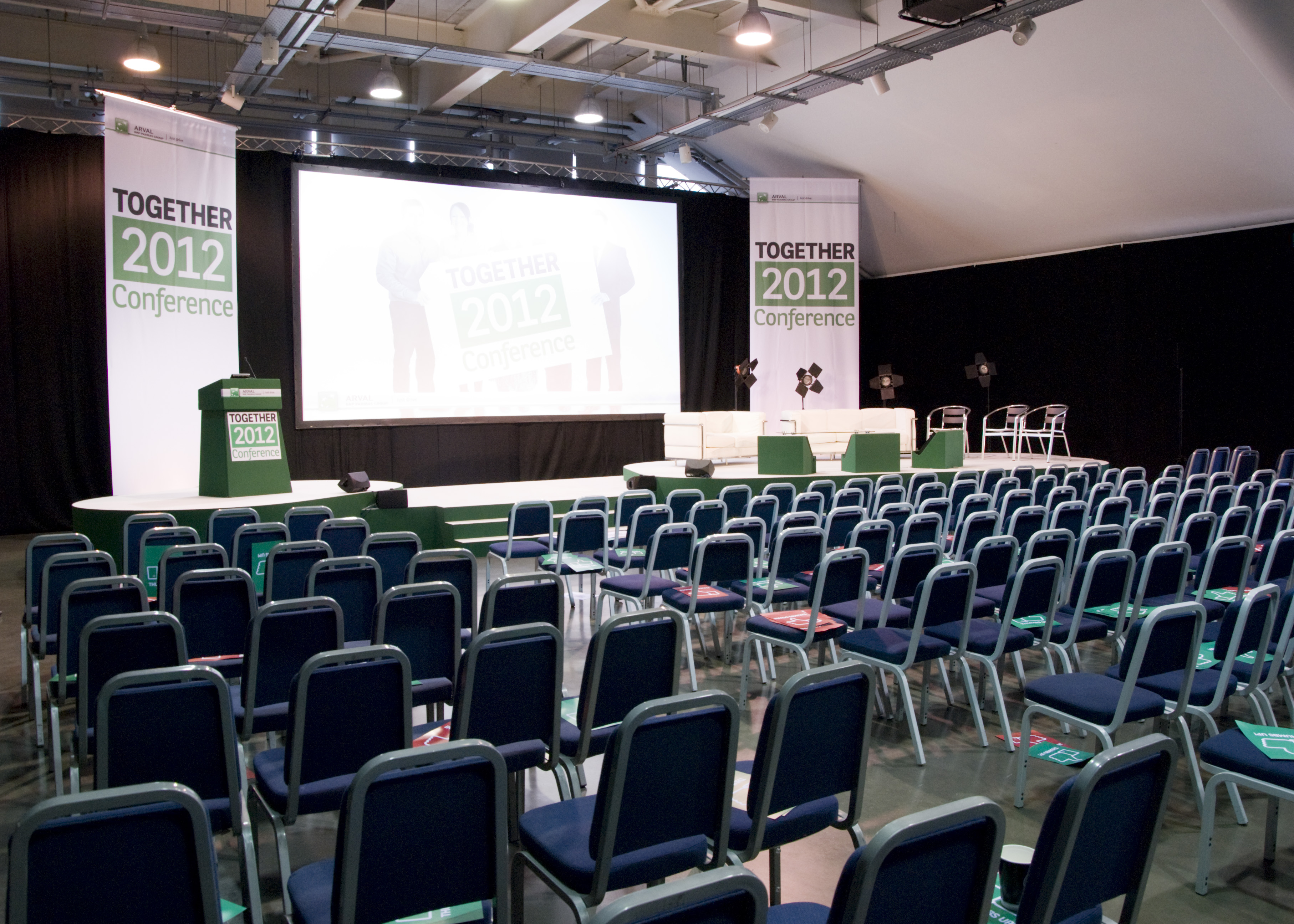 Newbury Racecourse Grandstand conference setup with stage and seating for events.