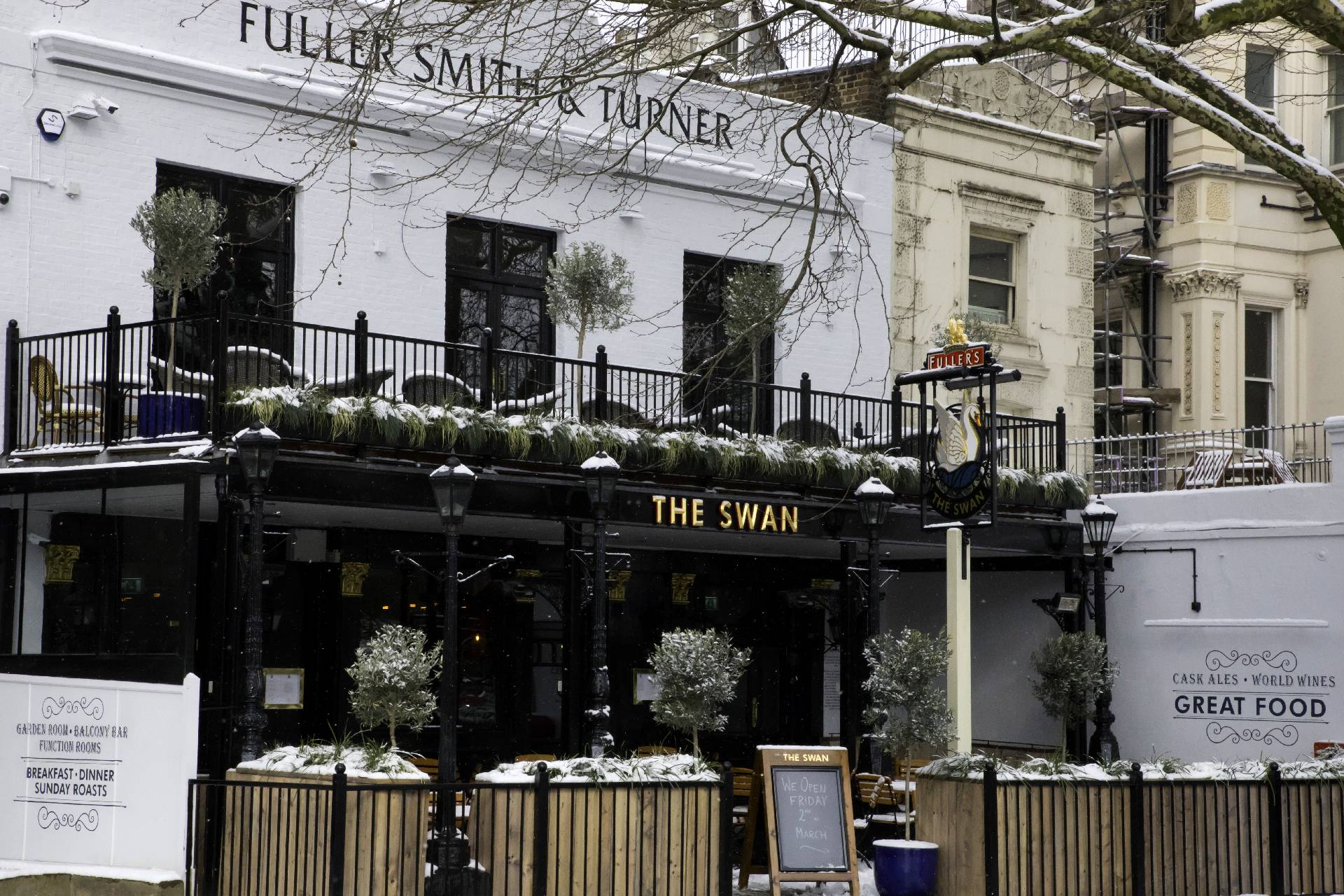 Charming Gallery Bar at The Swan, cozy winter venue with outdoor greenery for events.