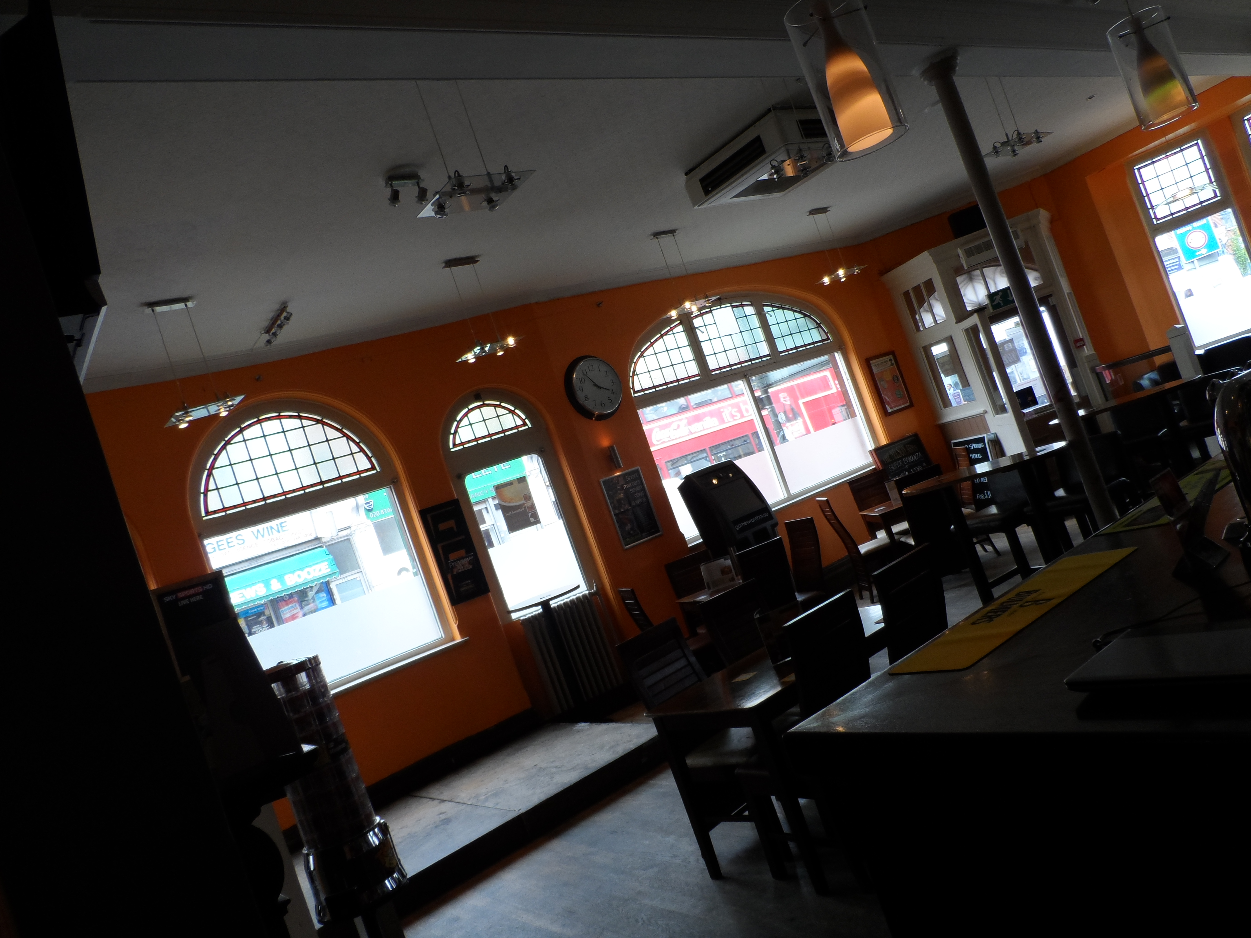 Cozy café venue with warm orange walls, perfect for meetings and networking events.