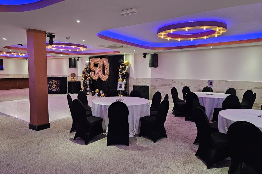 Black and white 50th birthday banquet event space at Praba Banqueting Suite with dance floor.