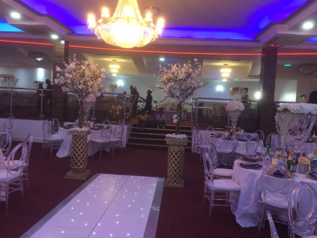 Banquet hall with LED dance floor and floral decor for gala reception and formal event.