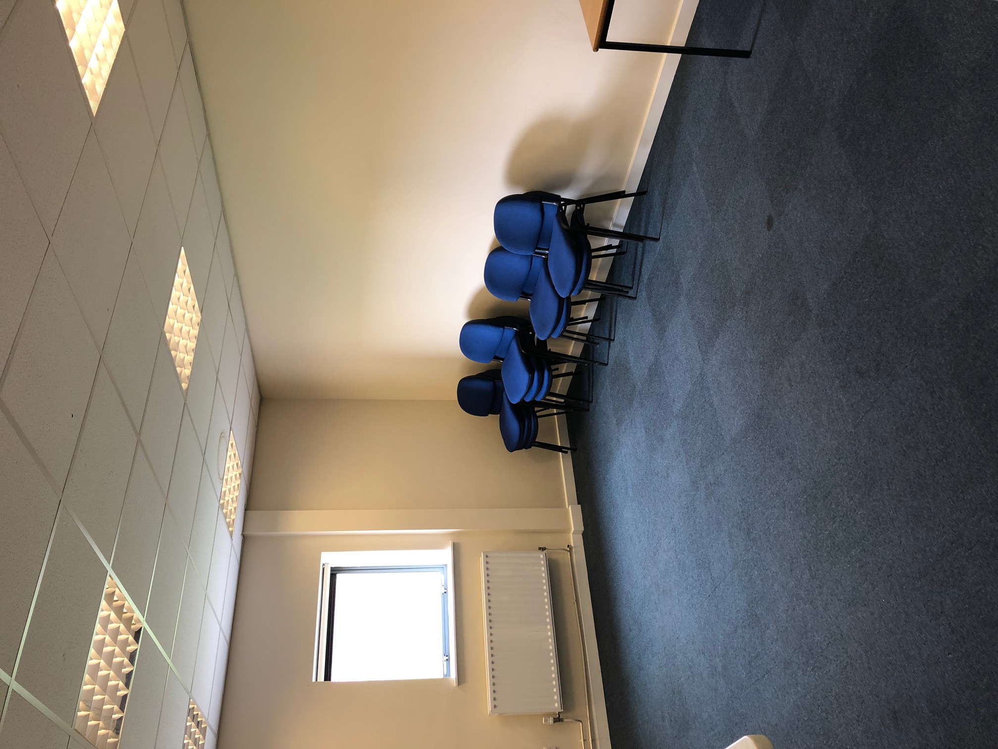 Conference room with blue chairs, ideal for meetings and brainstorming sessions.