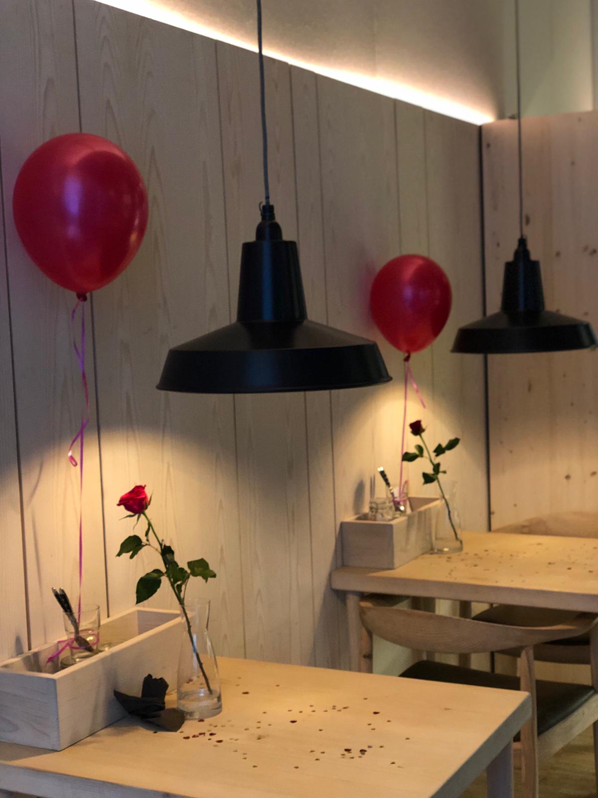 Cozy event setup in Stein's Berlin with warm lights, red balloons for intimate celebrations.