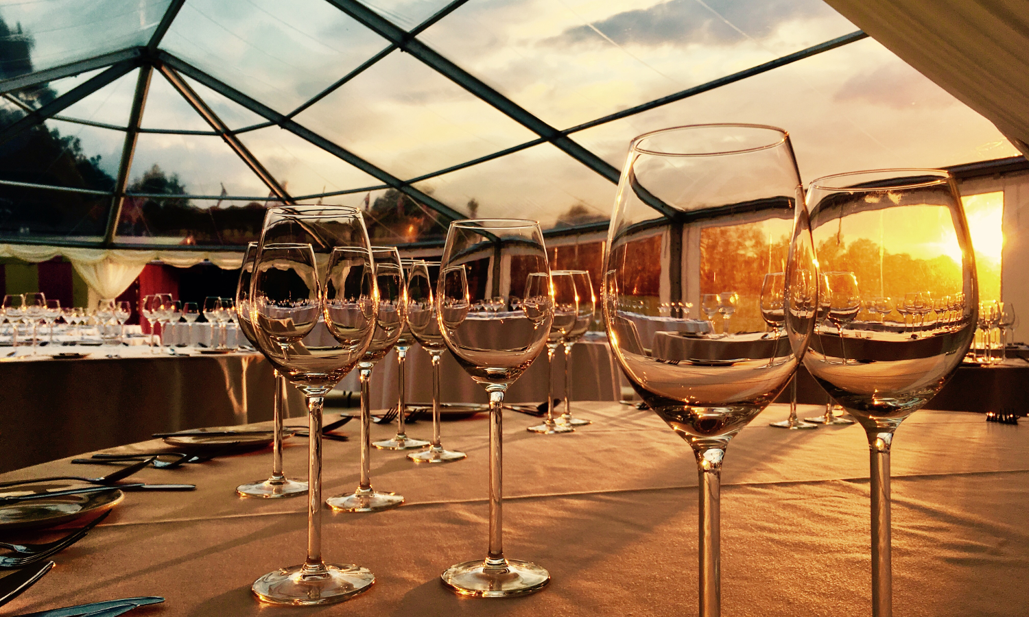 Elegant dining setup under glass canopy at South Lawns, perfect for upscale events.