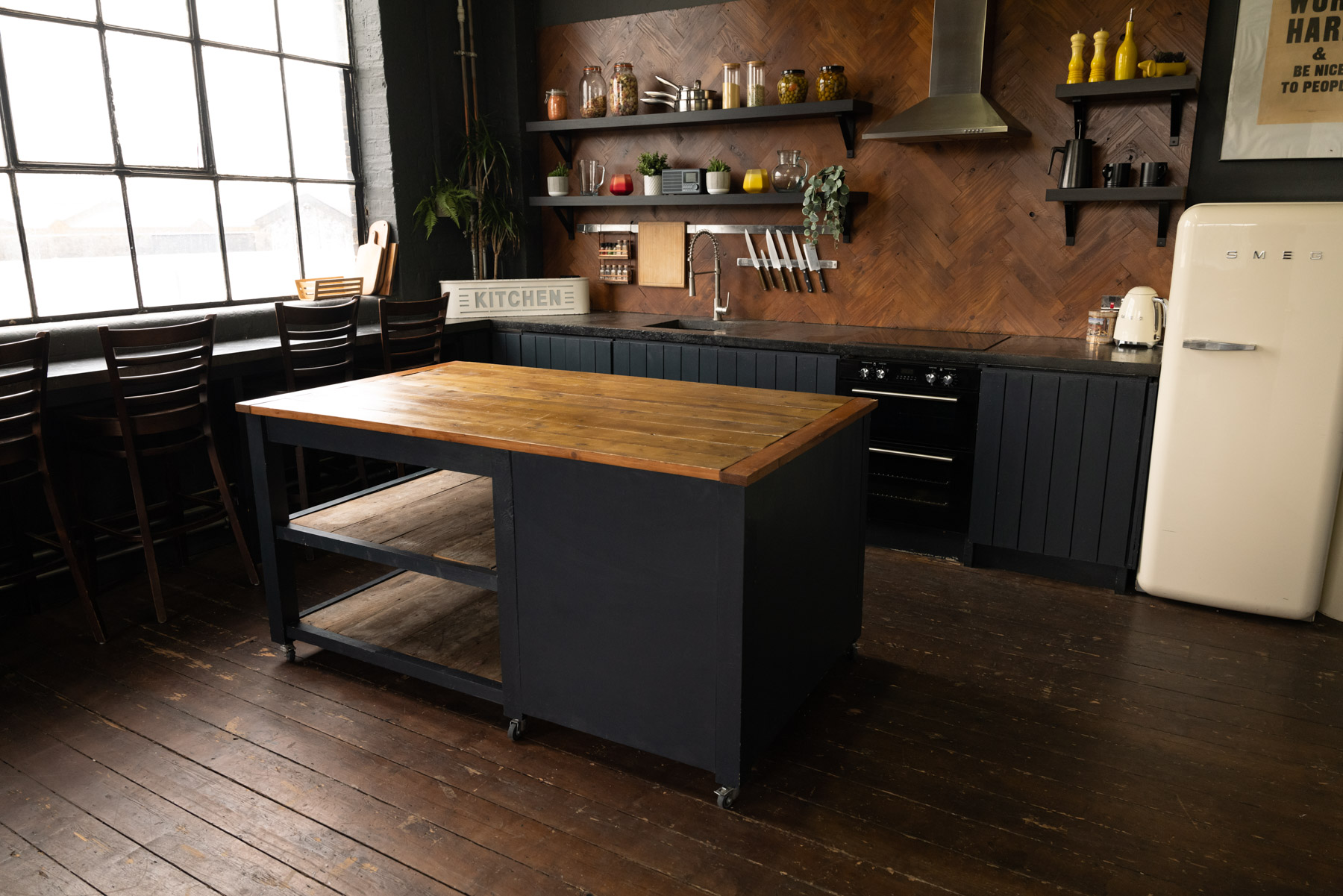 Stylish kitchen with rustic island for cooking classes and culinary events at Crixus Studios.