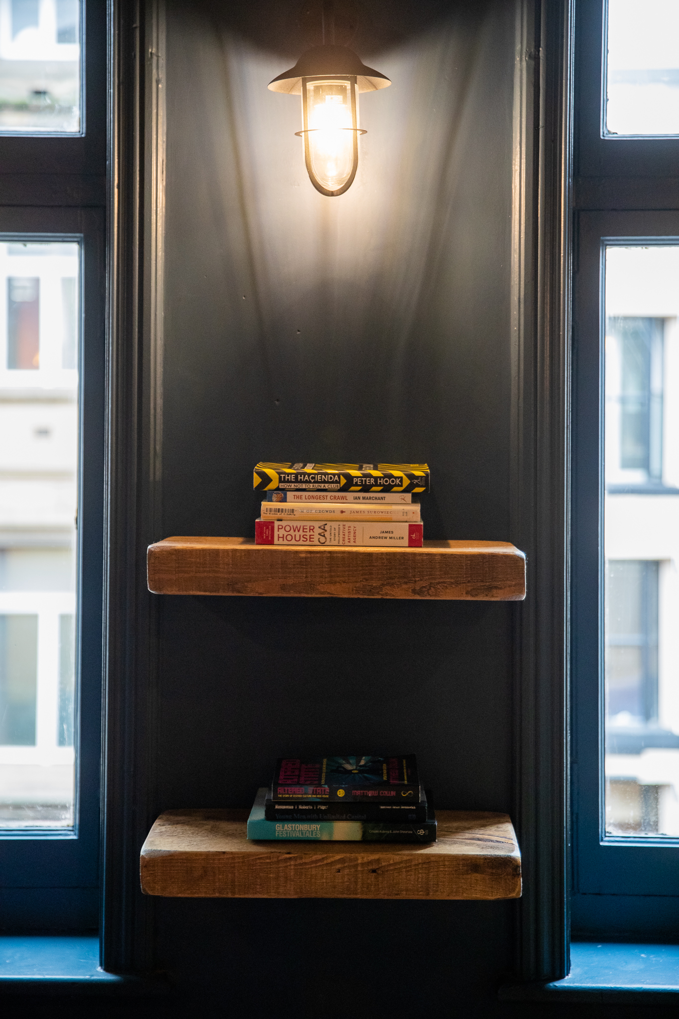 Minimalist bookshelf with curated books in modern event space at 33 Oldham Street.