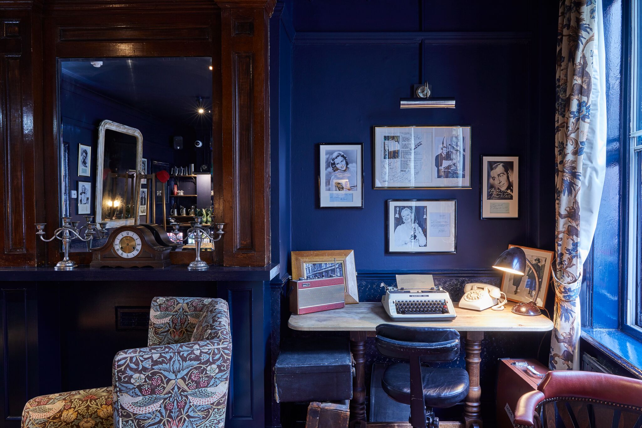 Cozy vintage meeting space with deep blue walls, ideal for workshops and team-building.
