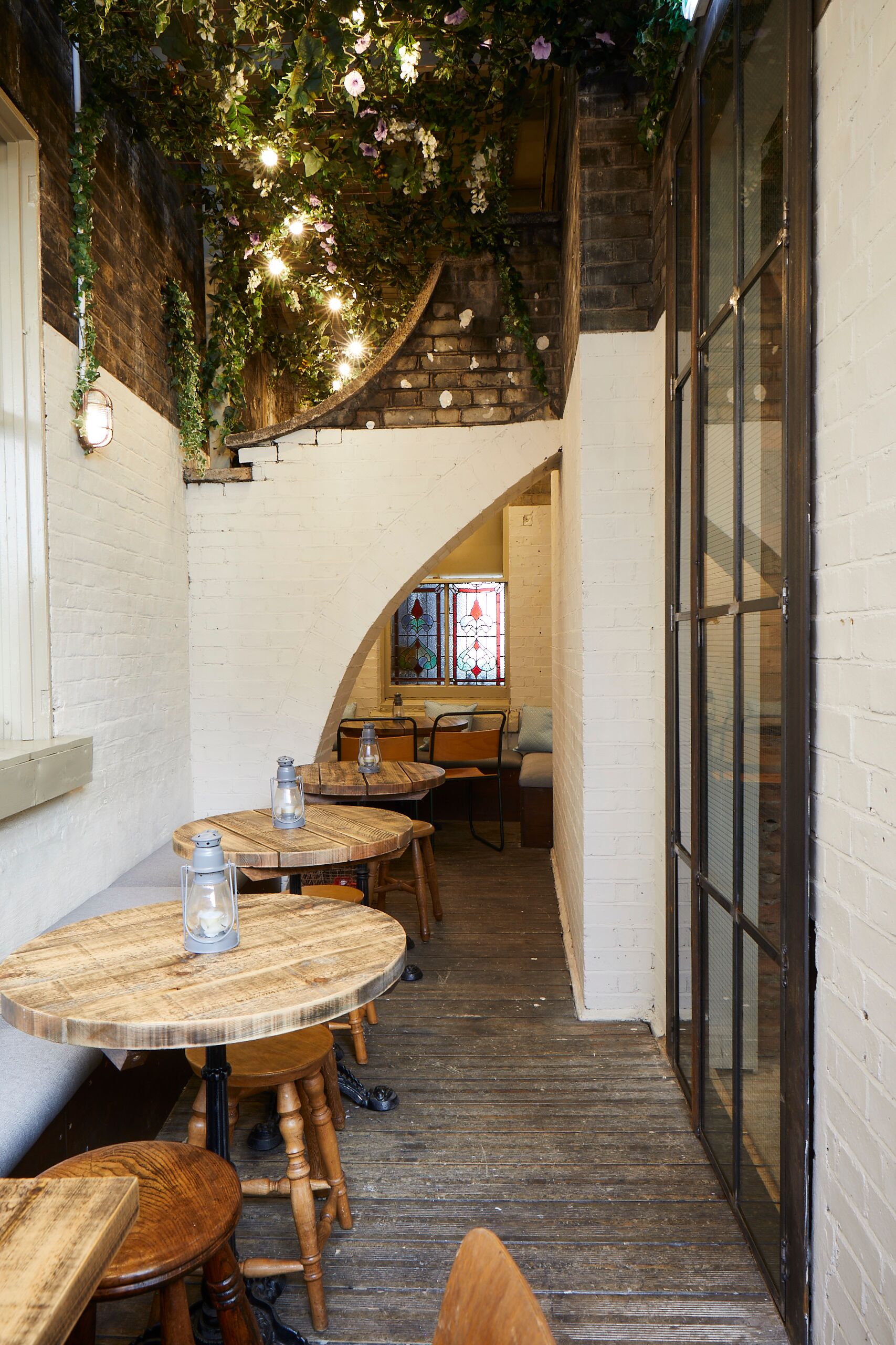 Intimate Gin Terrace at Bow Street Tavern with rustic tables, ideal for meetings and events.