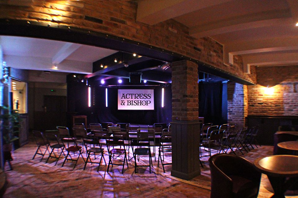 Versatile event space with stage and seating for intimate gatherings, ideal for presentations.