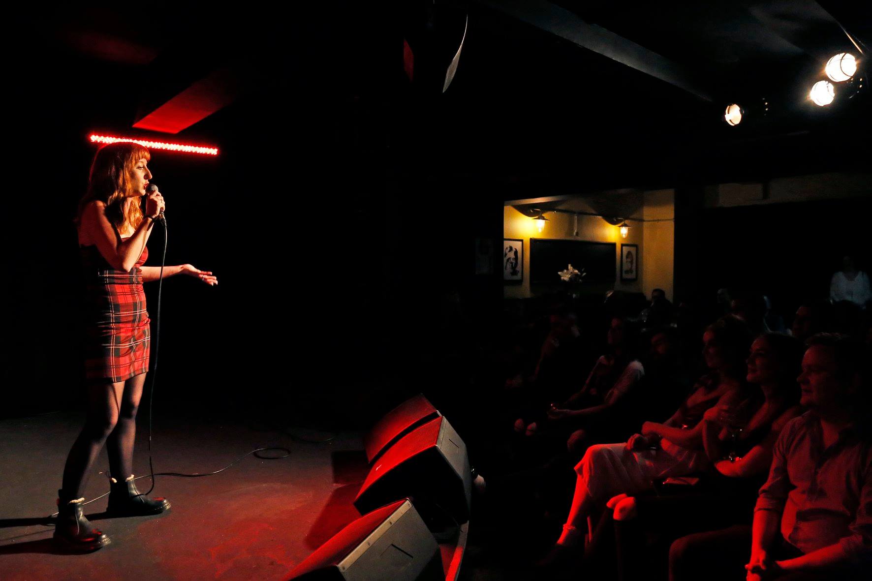 "Live performance at Actress and Bishop with spotlight on performer, ideal for comedy nights."