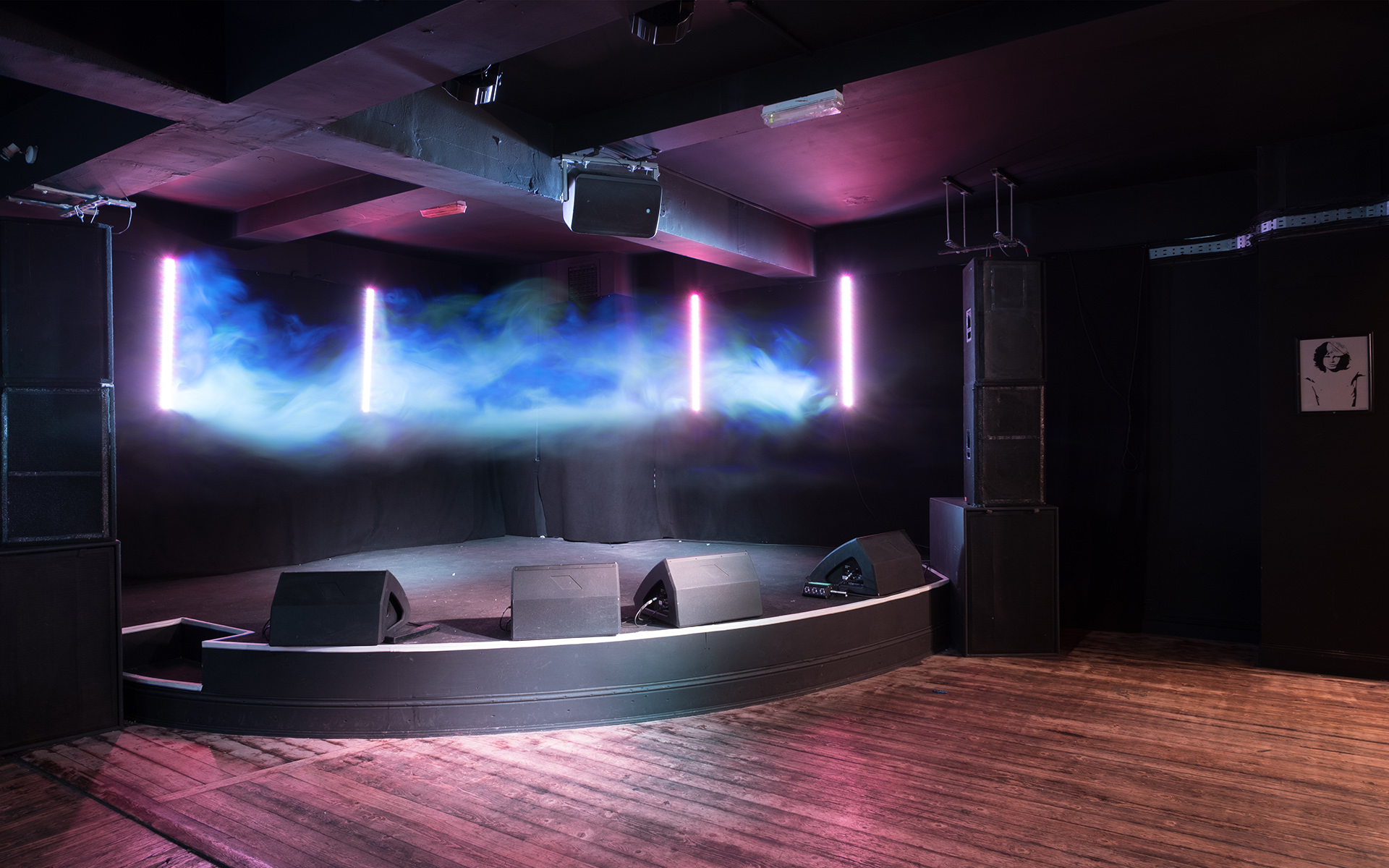 Versatile event space with sleek stage and modern lighting for concerts and corporate events.