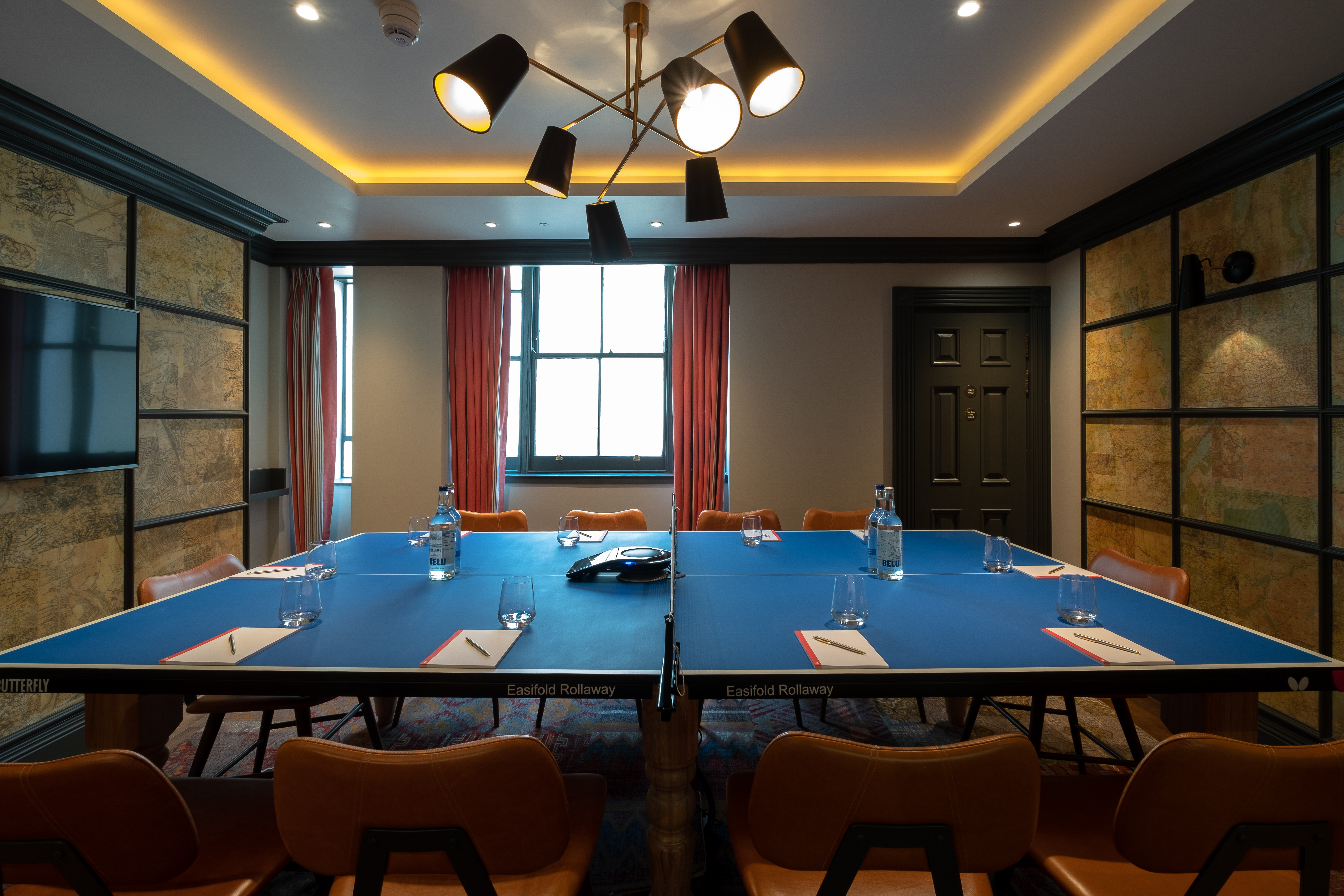 Modern meeting room with vibrant blue table for creative brainstorming at Home Grown Club.