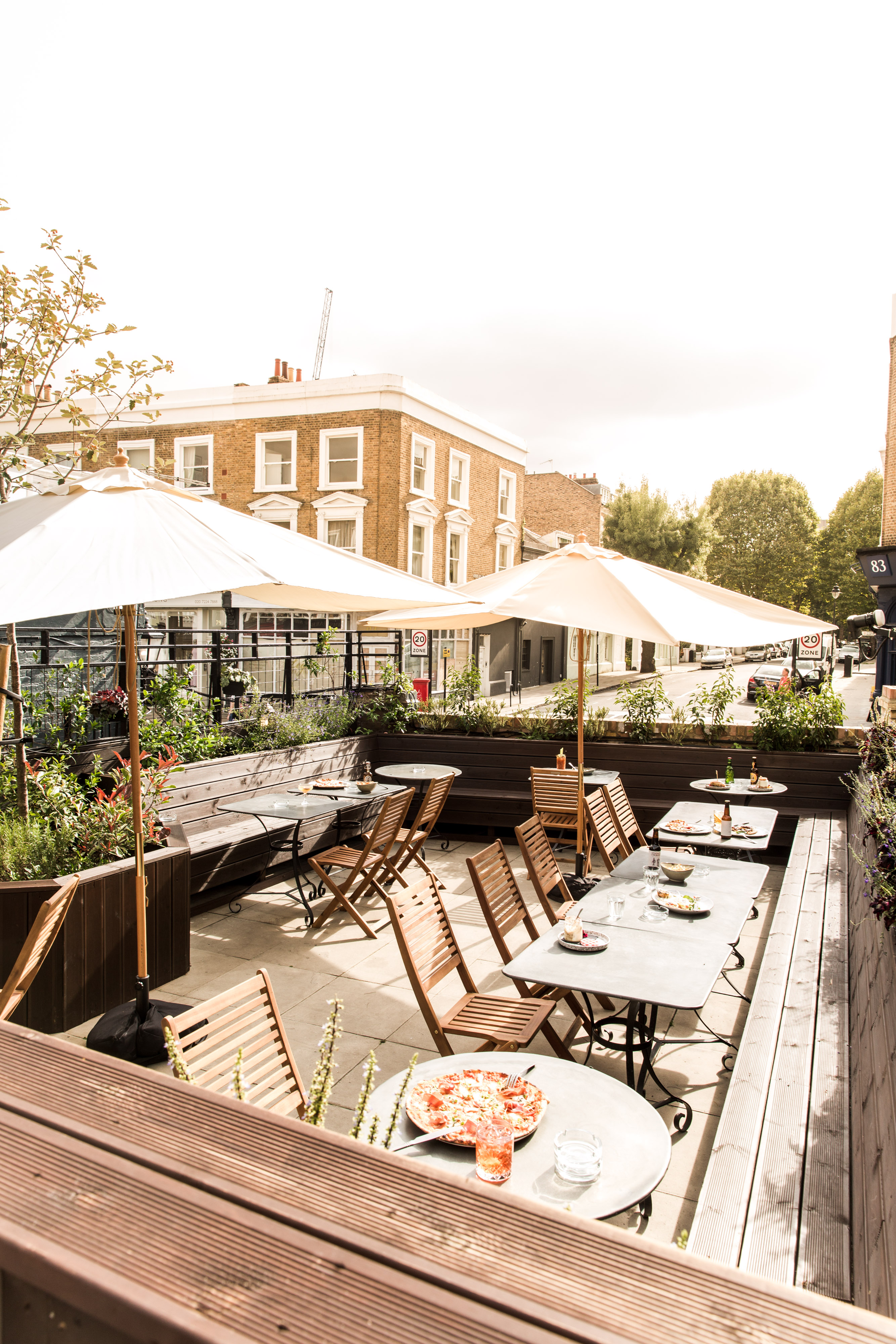 Charming outdoor event space with stylish seating and lush greenery for summer gatherings.