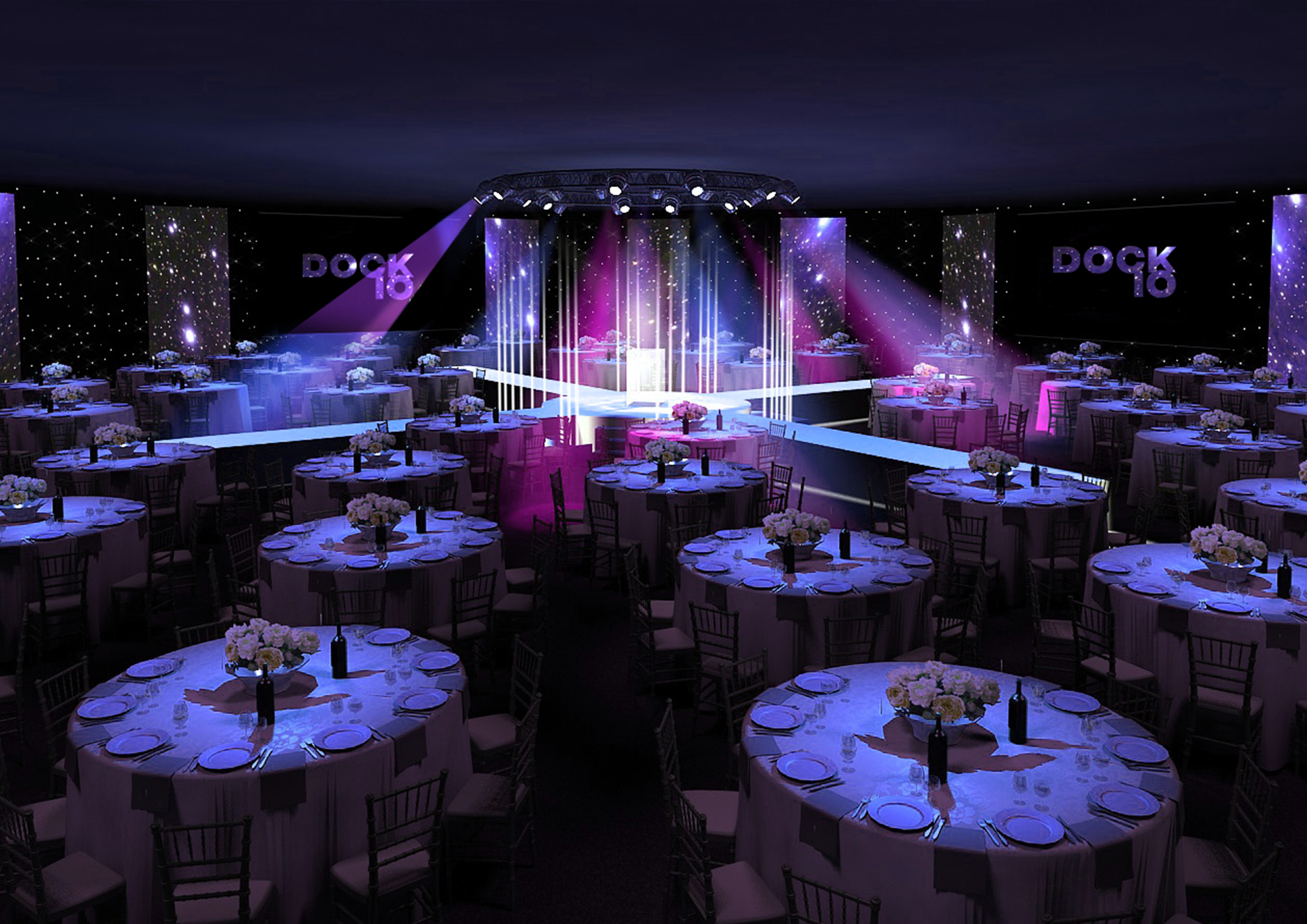 Elegant gala venue in Dock X London with floral centerpieces and vibrant stage lighting.