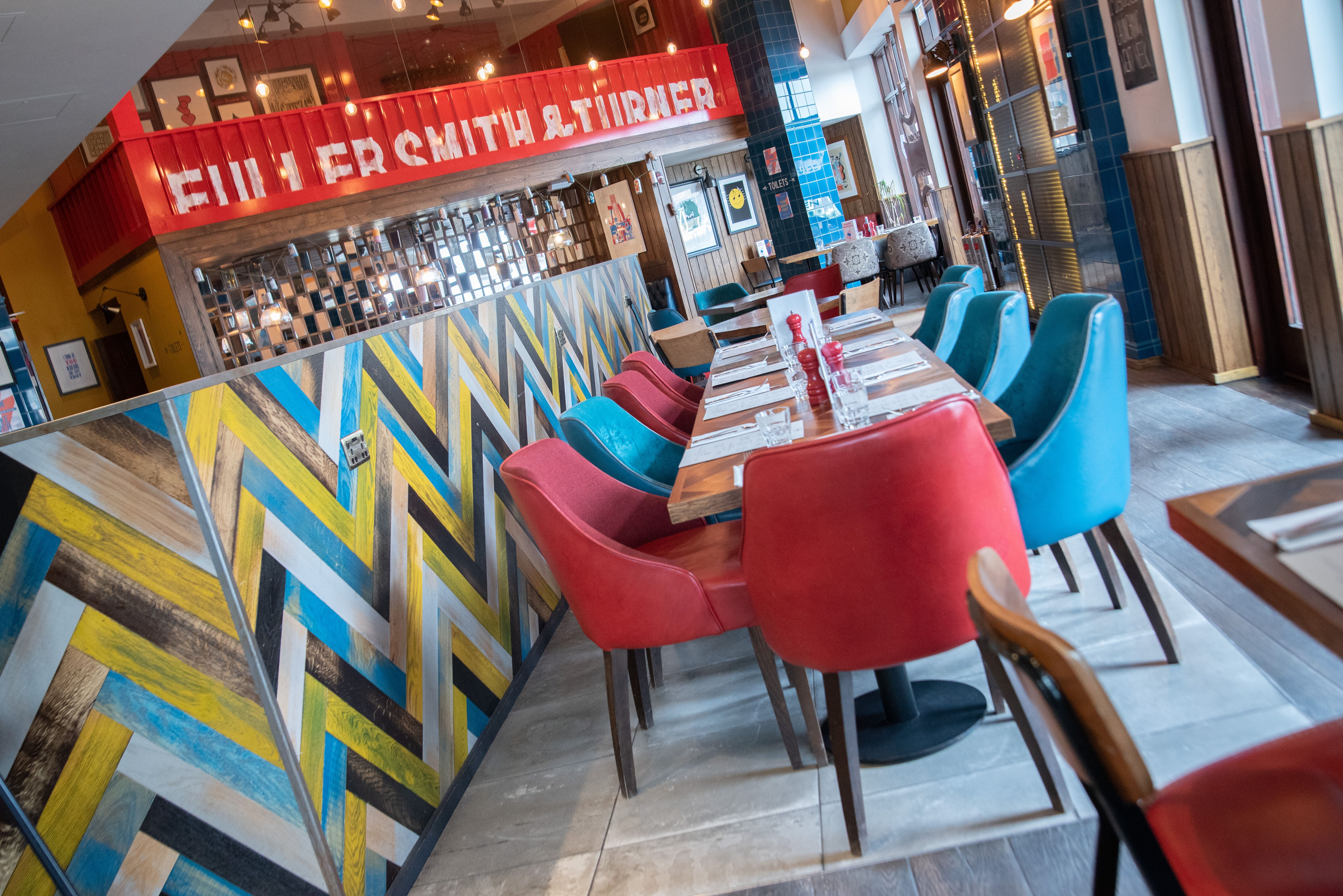 Vibrant restaurant with colorful chairs, ideal for casual meetings and events.