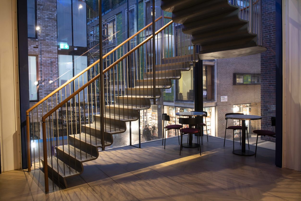 Modern restaurant staircase with large windows, perfect for networking events.