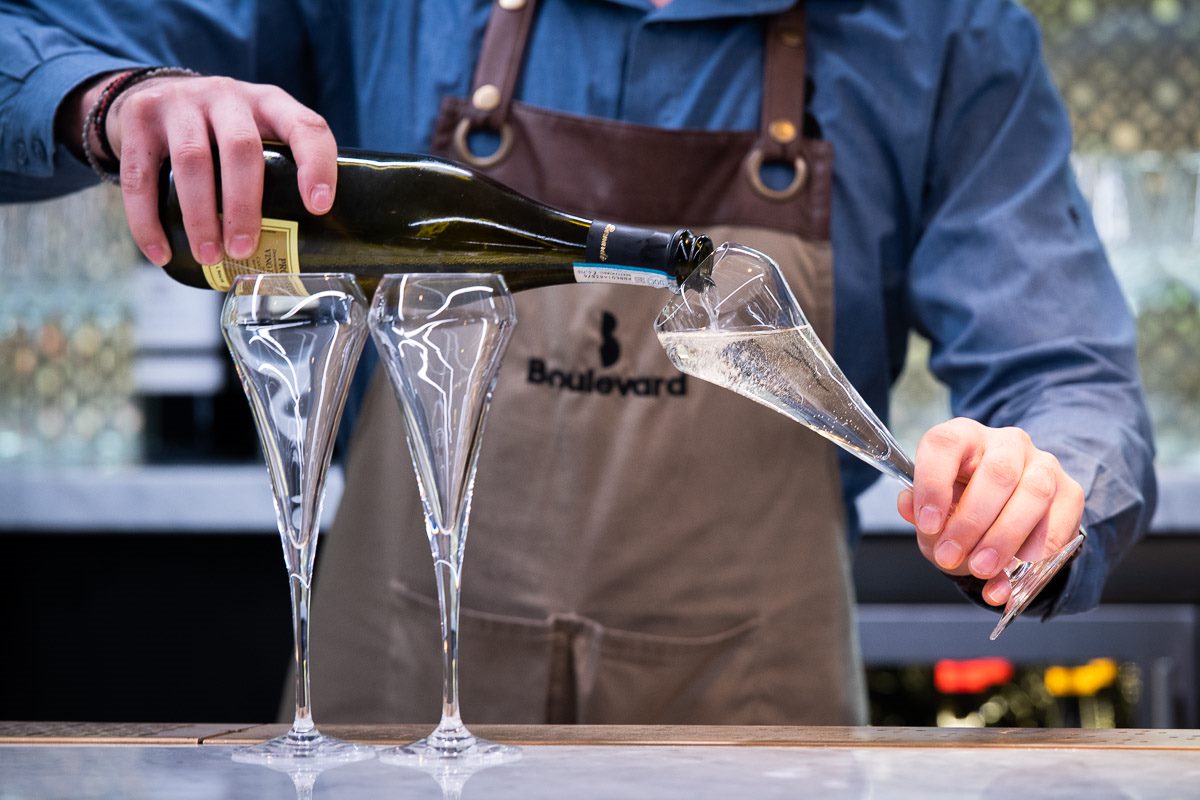 Bartender pouring champagne in elegant flutes at Stalls Lounge for weddings and events.