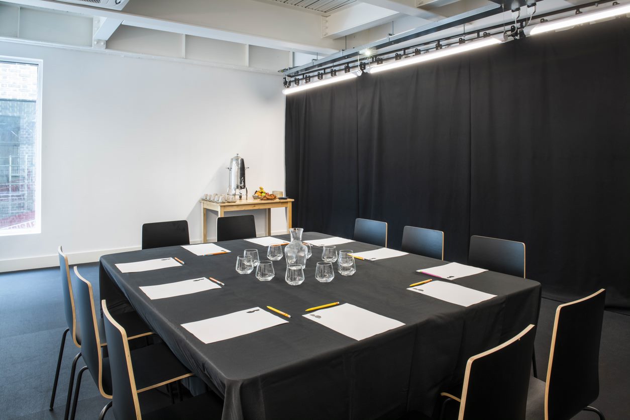 Professional rehearsal room with minimalistic setup for focused discussions and meetings.