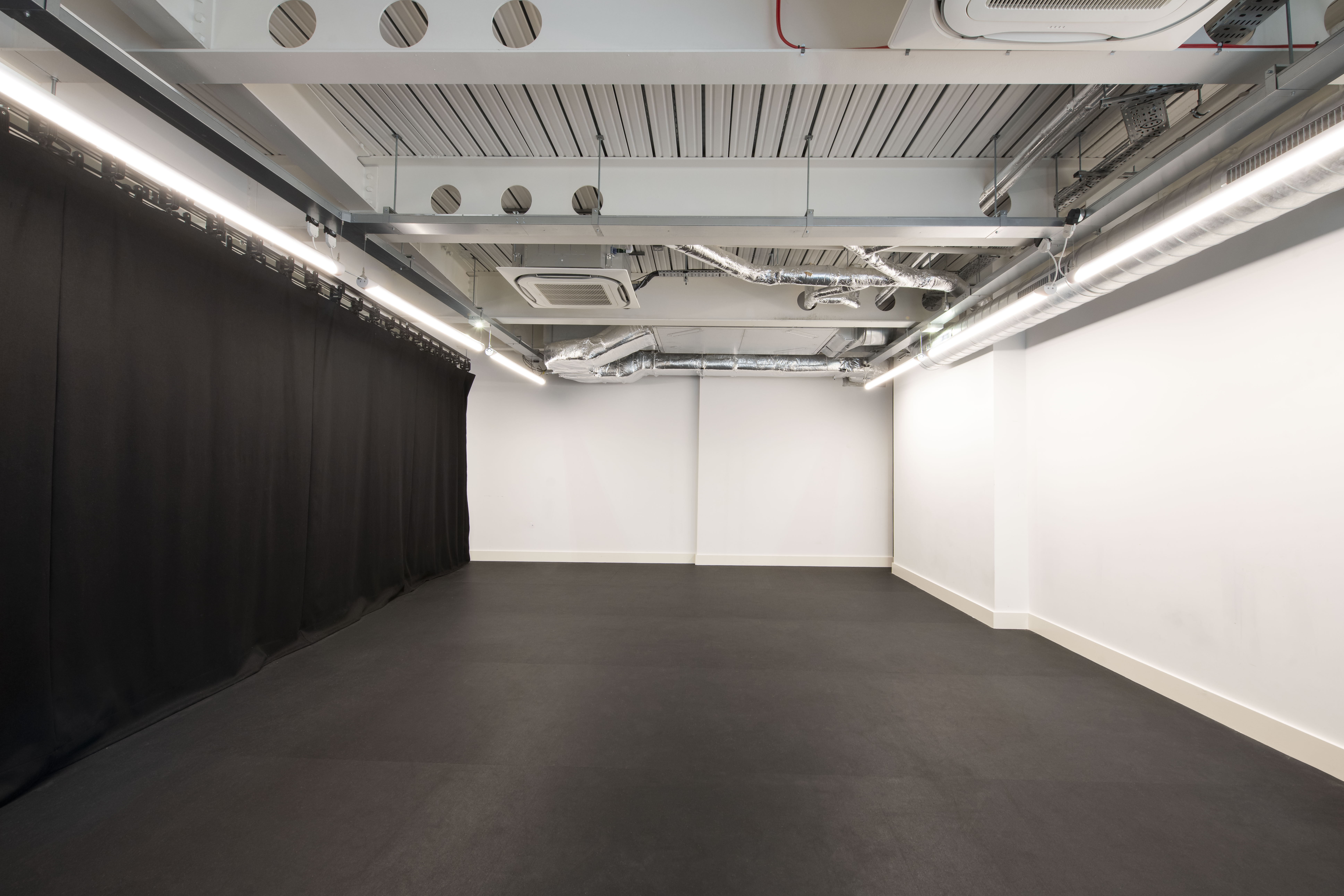 Flexible rehearsal room with minimalist design, perfect for workshops and events.