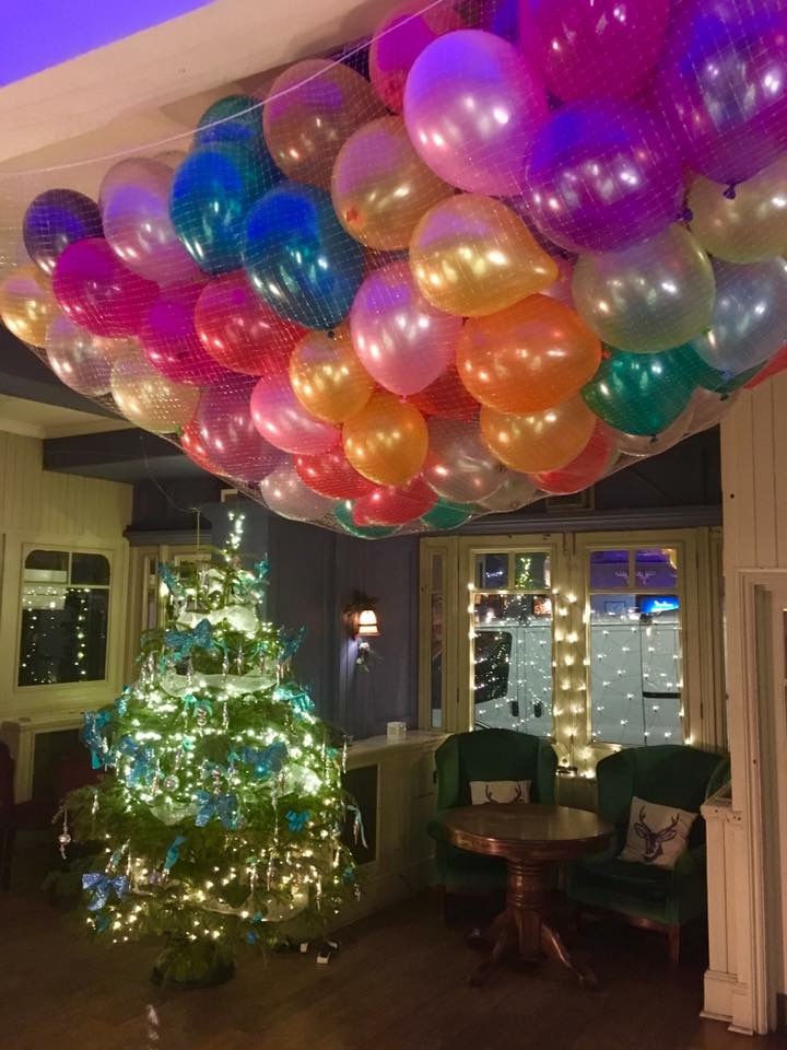 Vibrant event space with colorful balloon ceiling for festive parties and gatherings.
