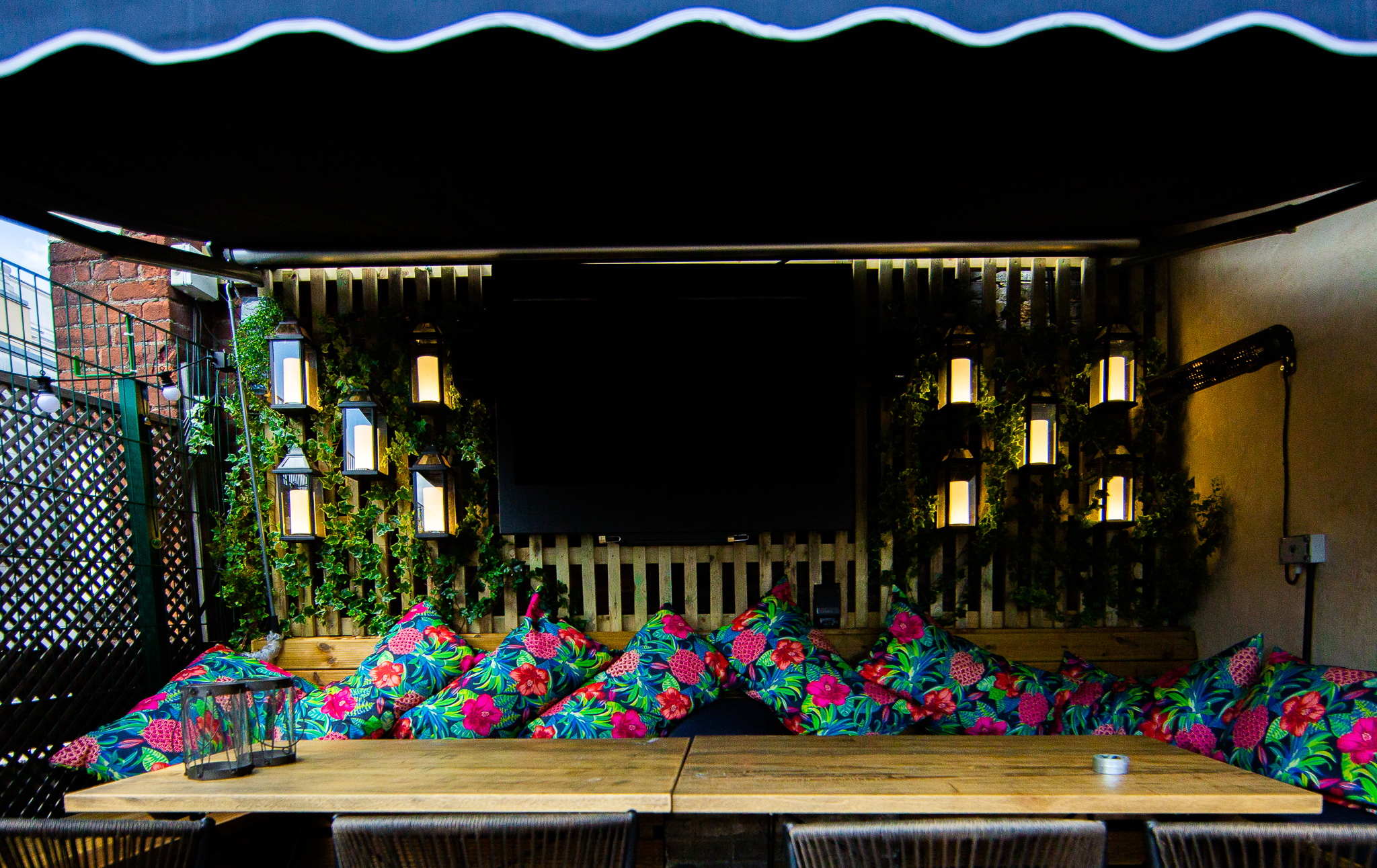 Vibrant outdoor meeting space at Bow Street Tavern with floral cushions and lanterns.