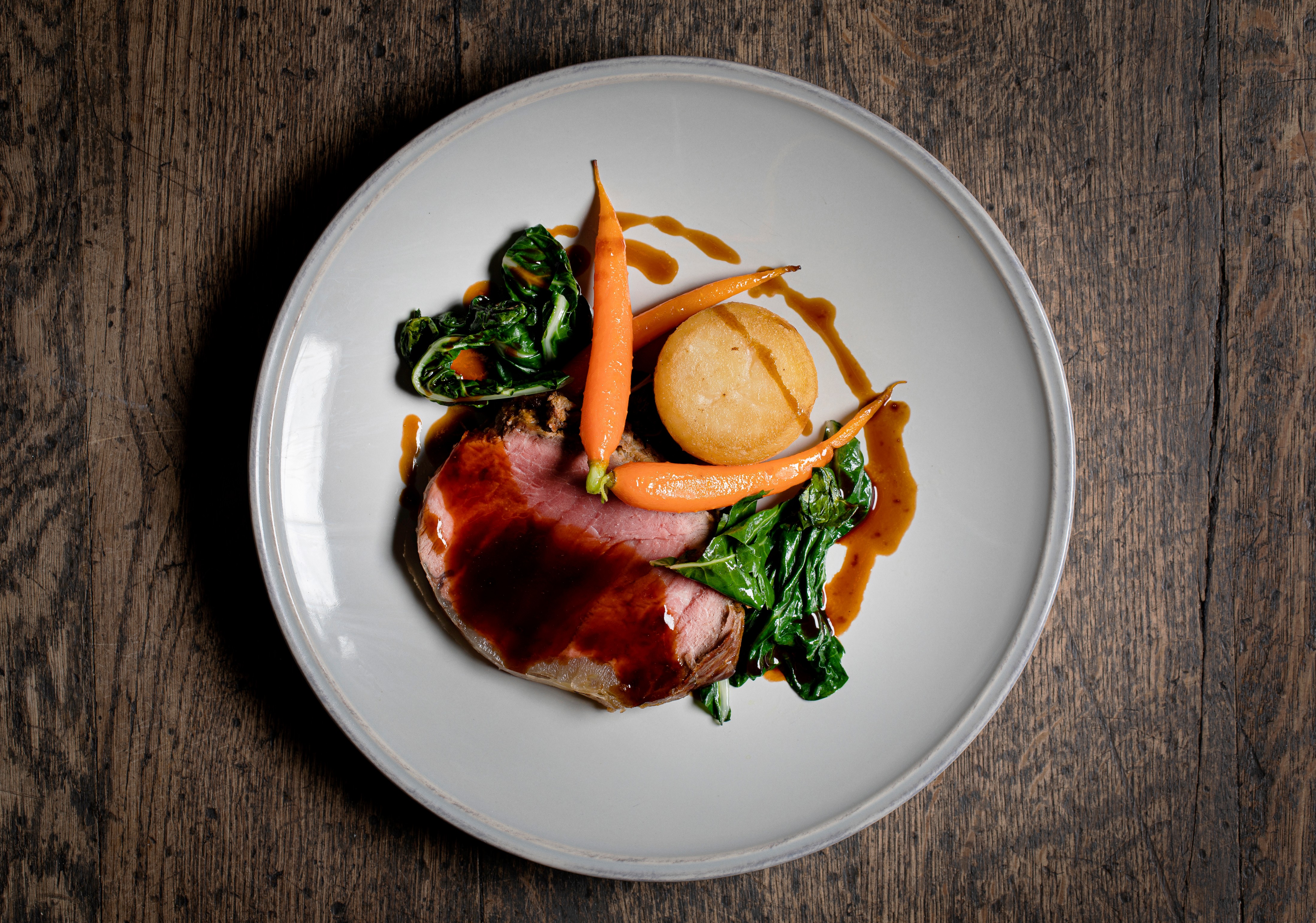 Succulent roasted meat dish with baby carrots at Swan at The Globe event venue.