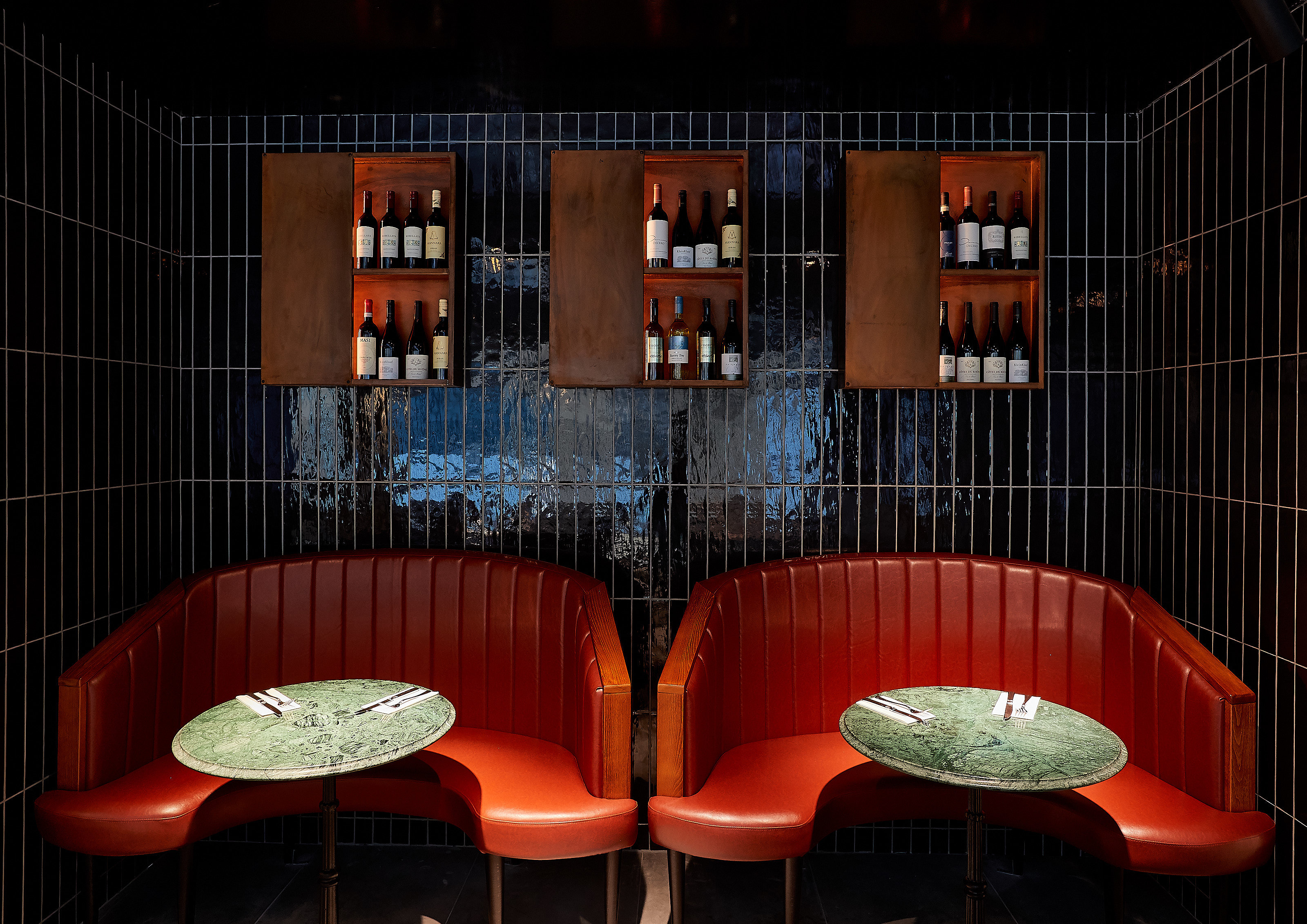 Intimate seating area with red booths in Gunpowder Tower Bridge for networking events.